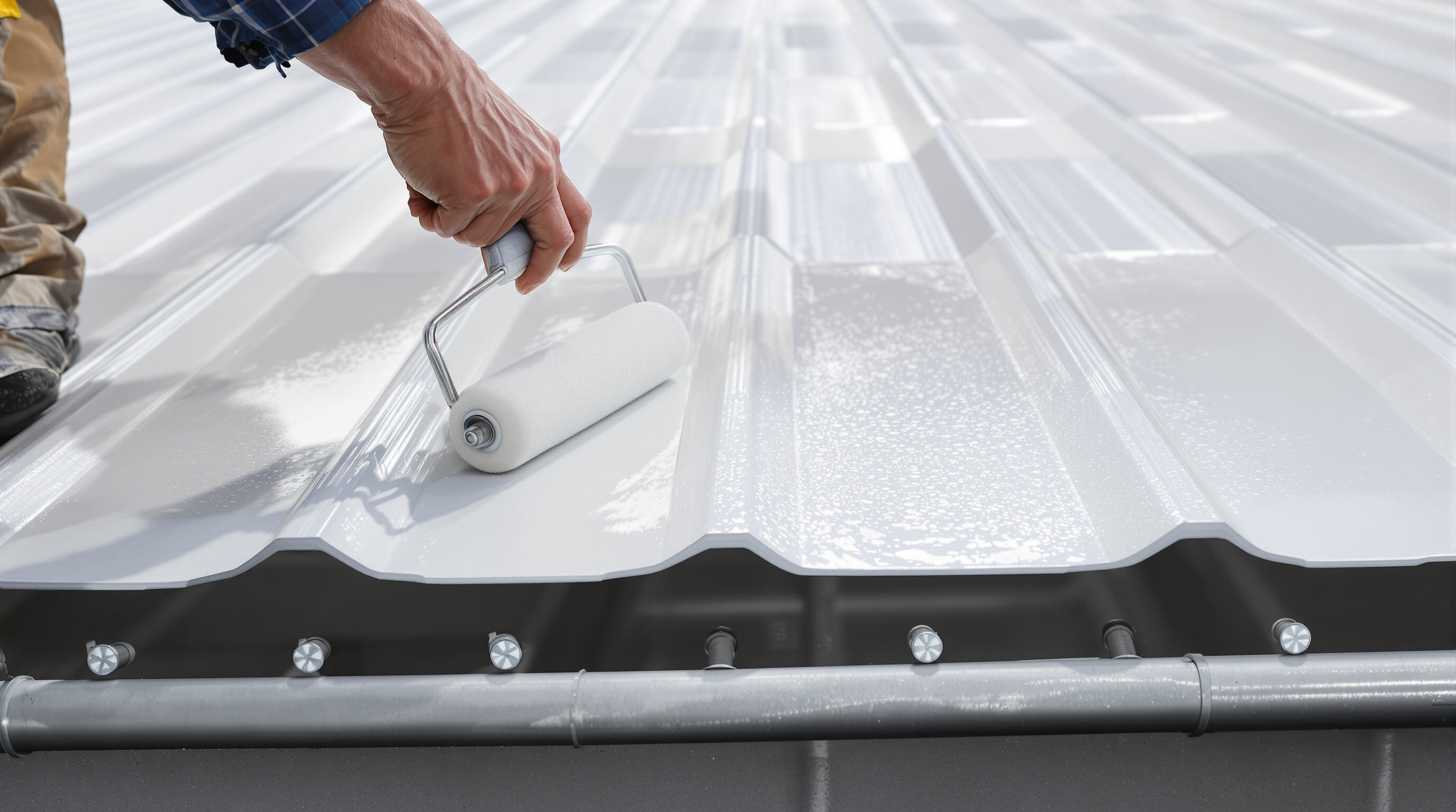 Worker applying protective coating to properly installed UPVC roofing sheets with aligned fasteners