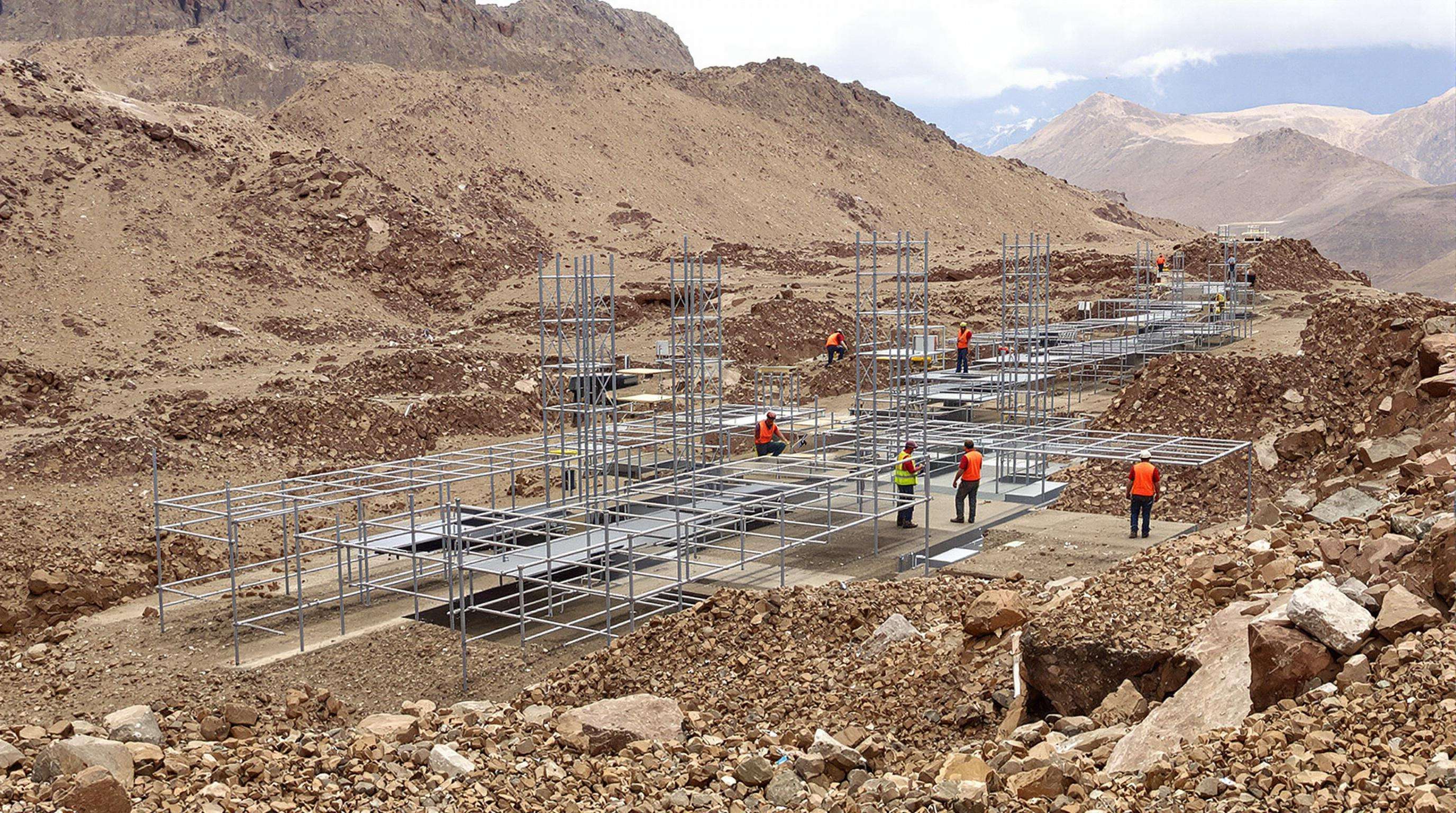 Engineers inspecting modular steel and polymer obstacles on an endurance racing course integrated into natural terrain