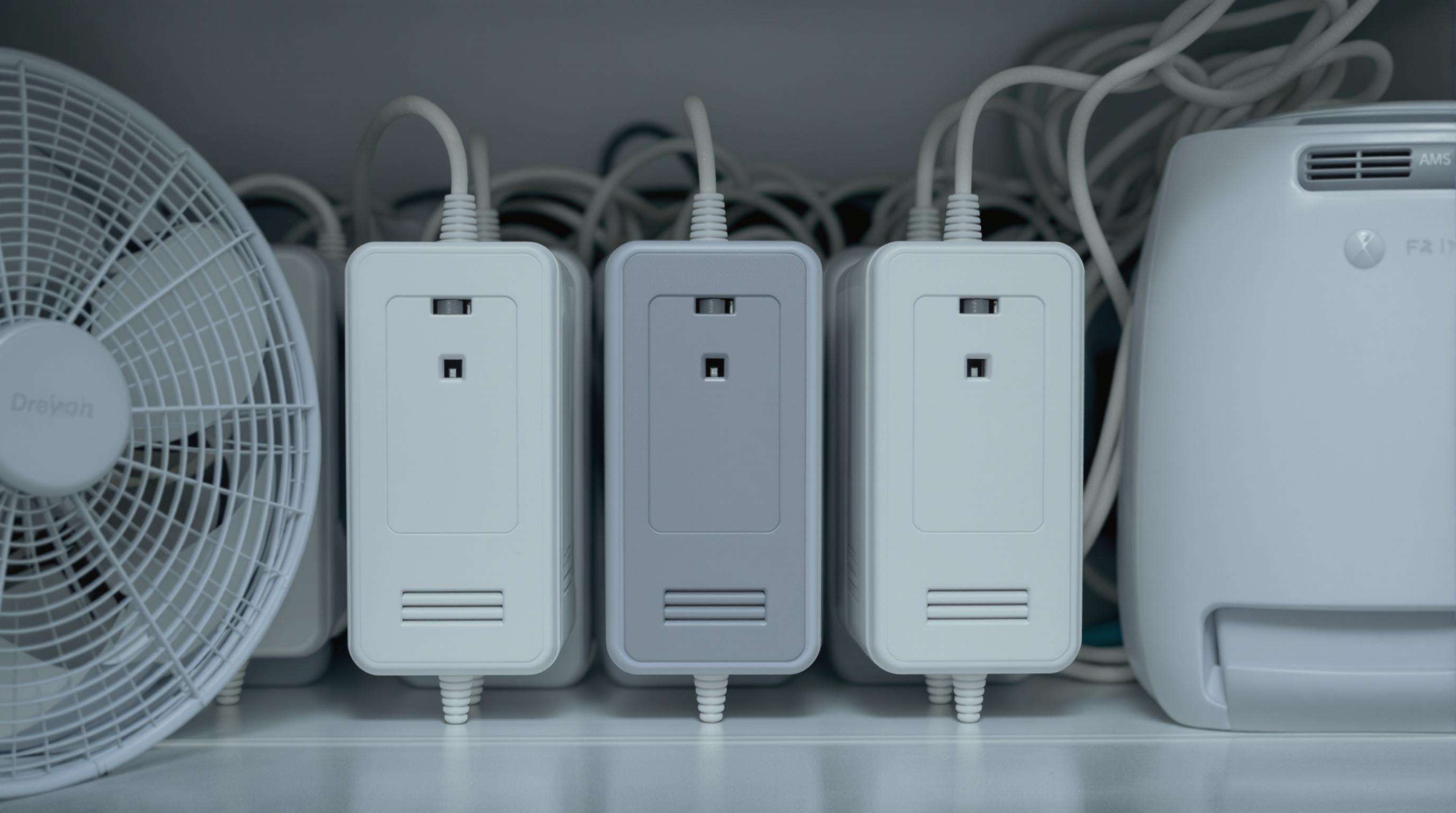 AC adapters positioned with clear spacing for ventilation, visible vents, cooling fan and dehumidifier present