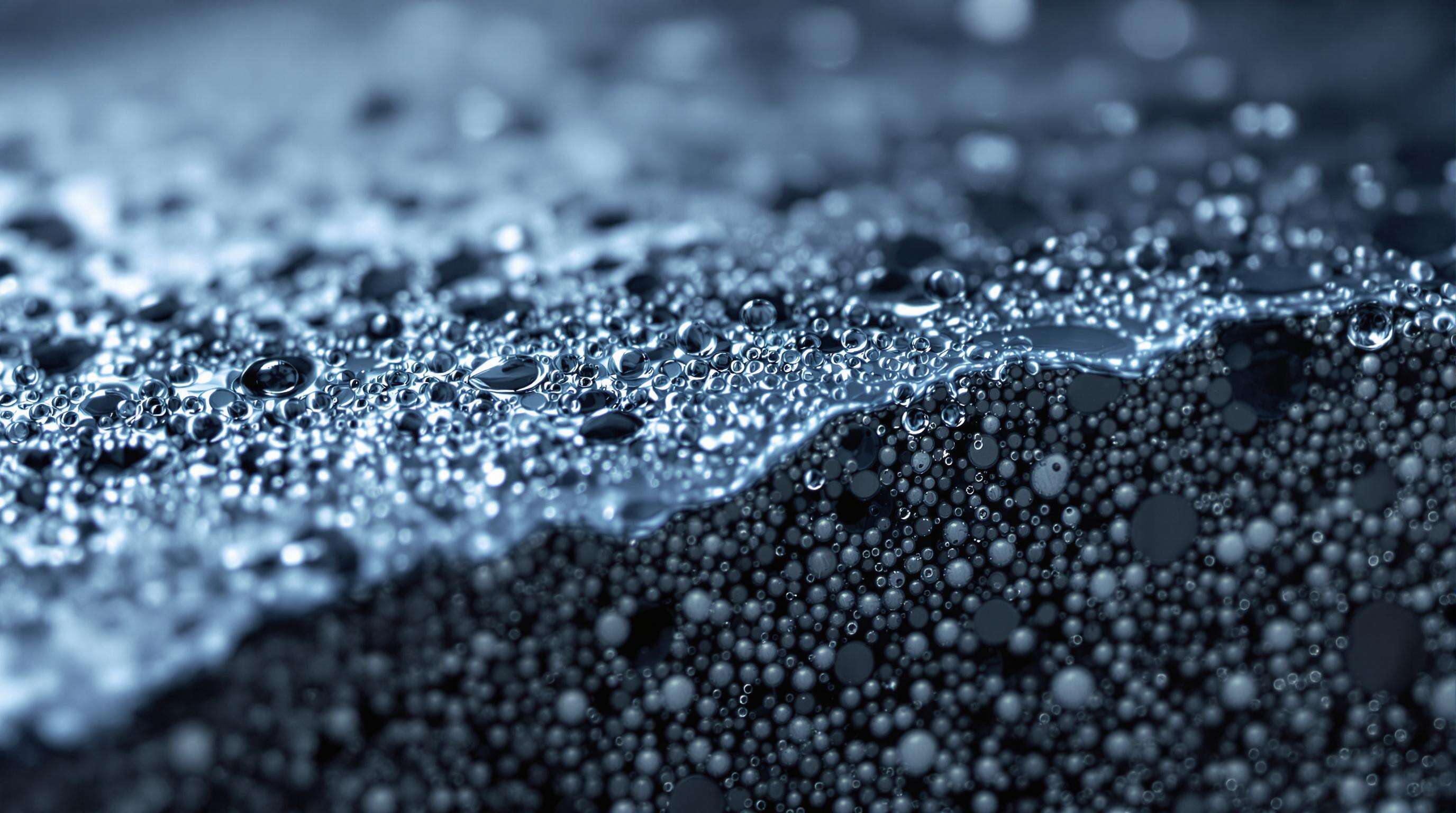 Macro photograph of activated carbon particles in water, highlighting porous surfaces and contaminant interaction