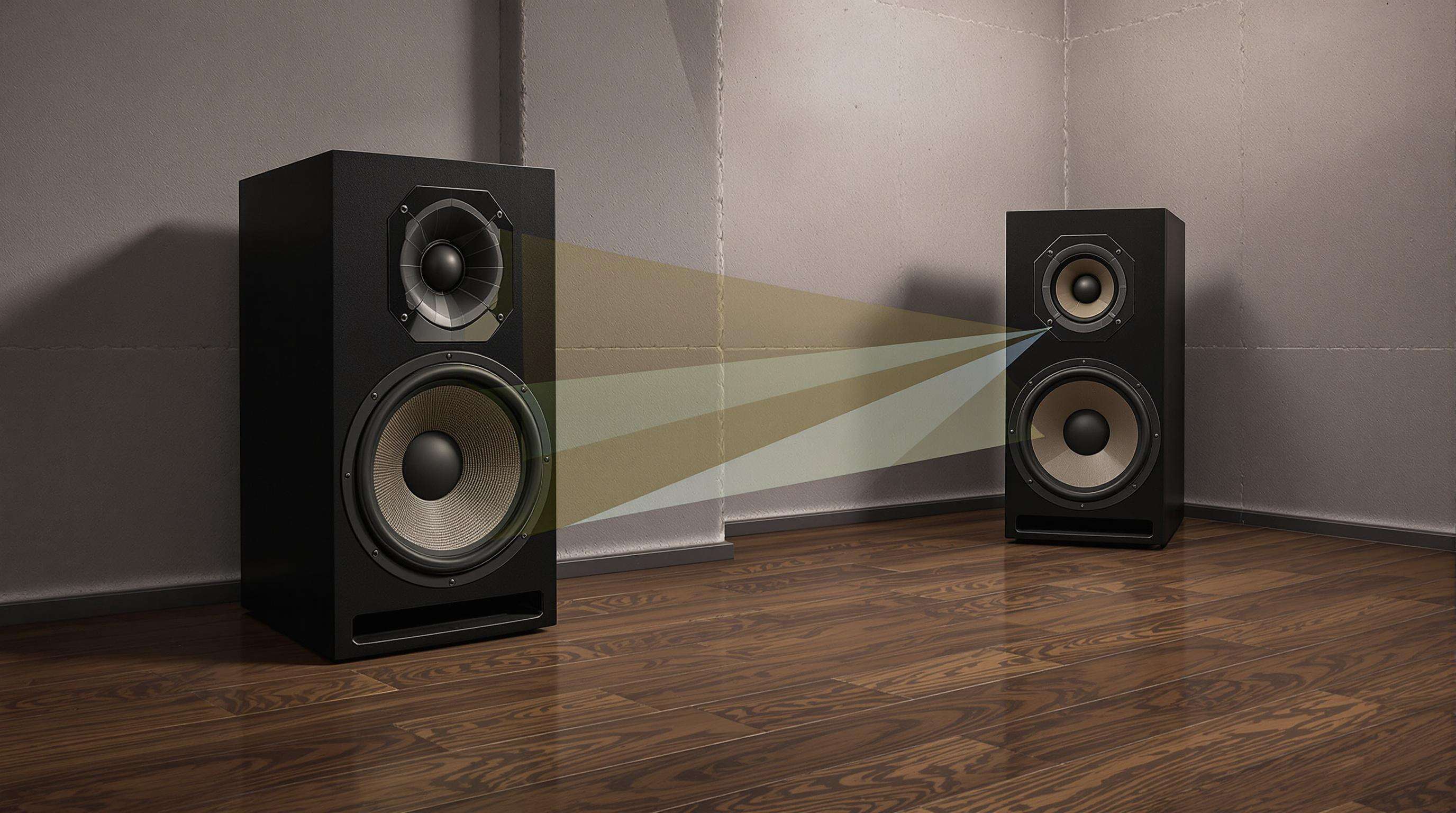 A photorealistic image of subwoofers set near a concrete wall and in a room corner to illustrate boundary reinforcement.