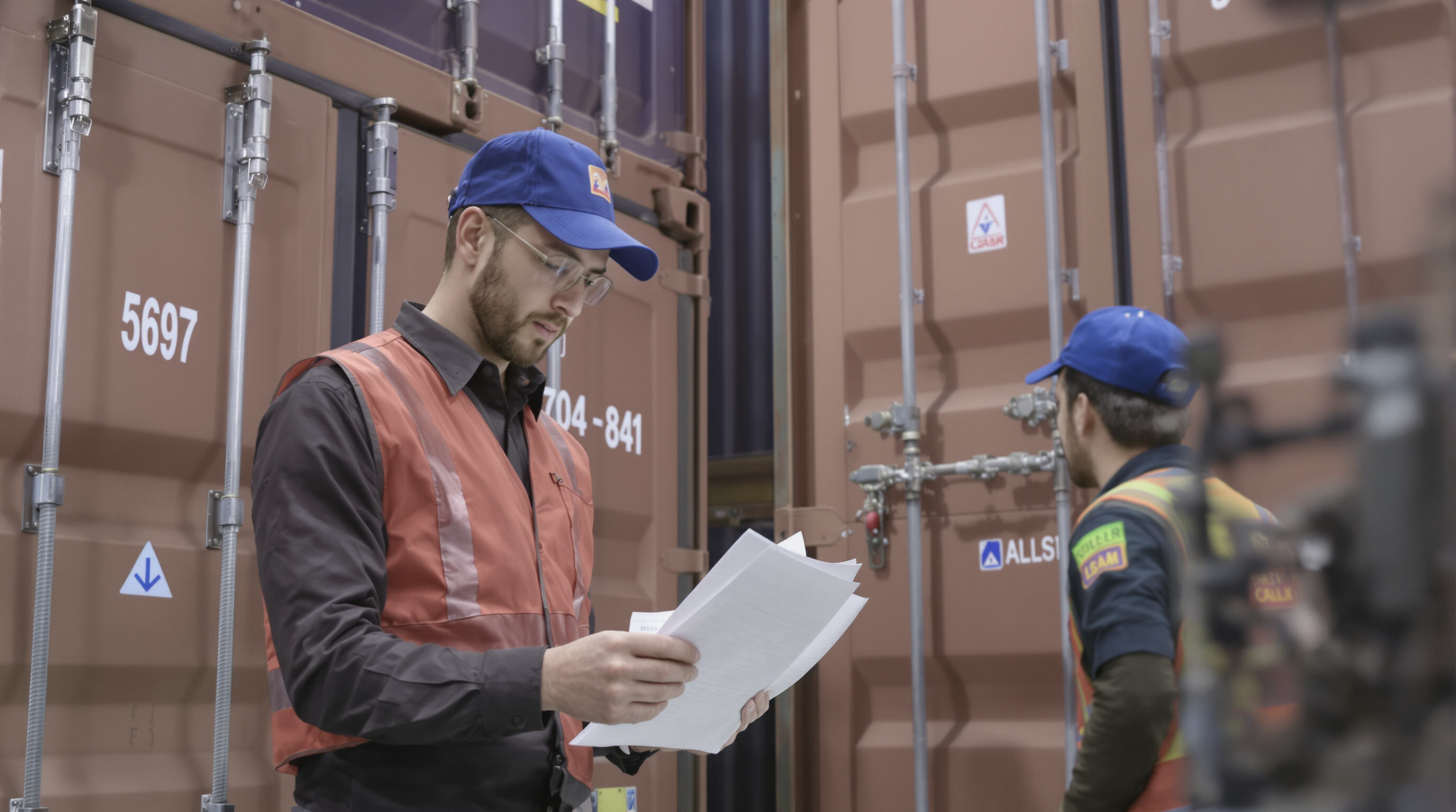 Customs officer examining shipping documents with cargo containers at a customs checkpoint