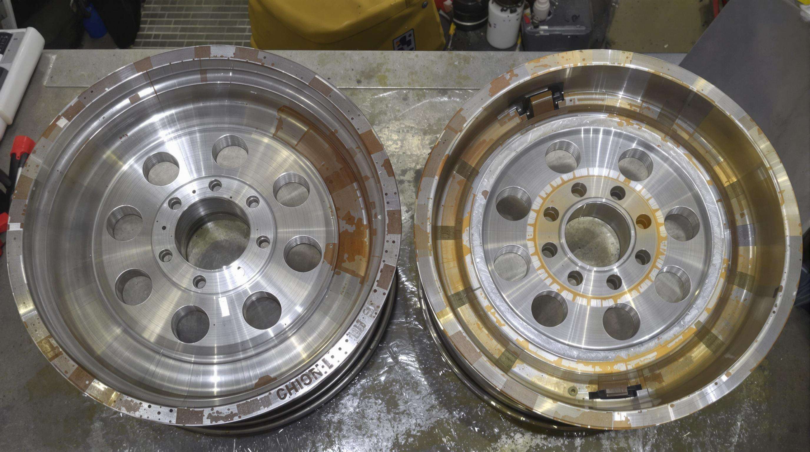 Forged and cast wheels cut open side by side, highlighting their internal metal structure differences
