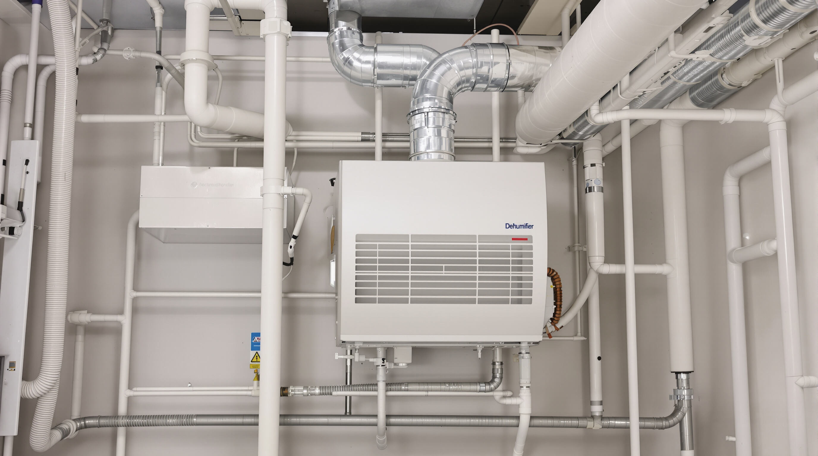 Integrated dehumidifier and HVAC system components connected in a building mechanical room