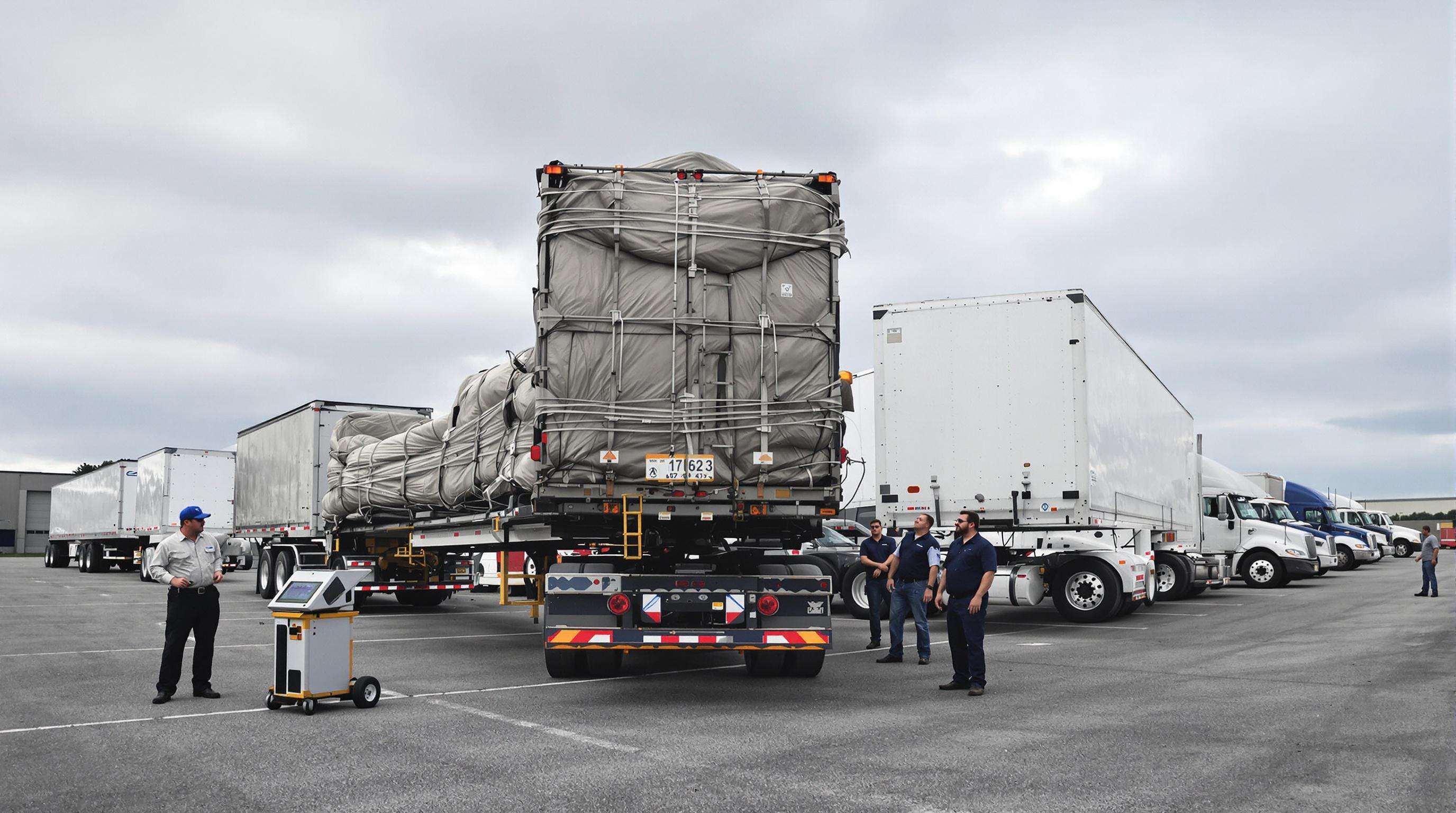Technician weighing loaded cargo trucks with different trailers, emphasizing towing limits and load safety