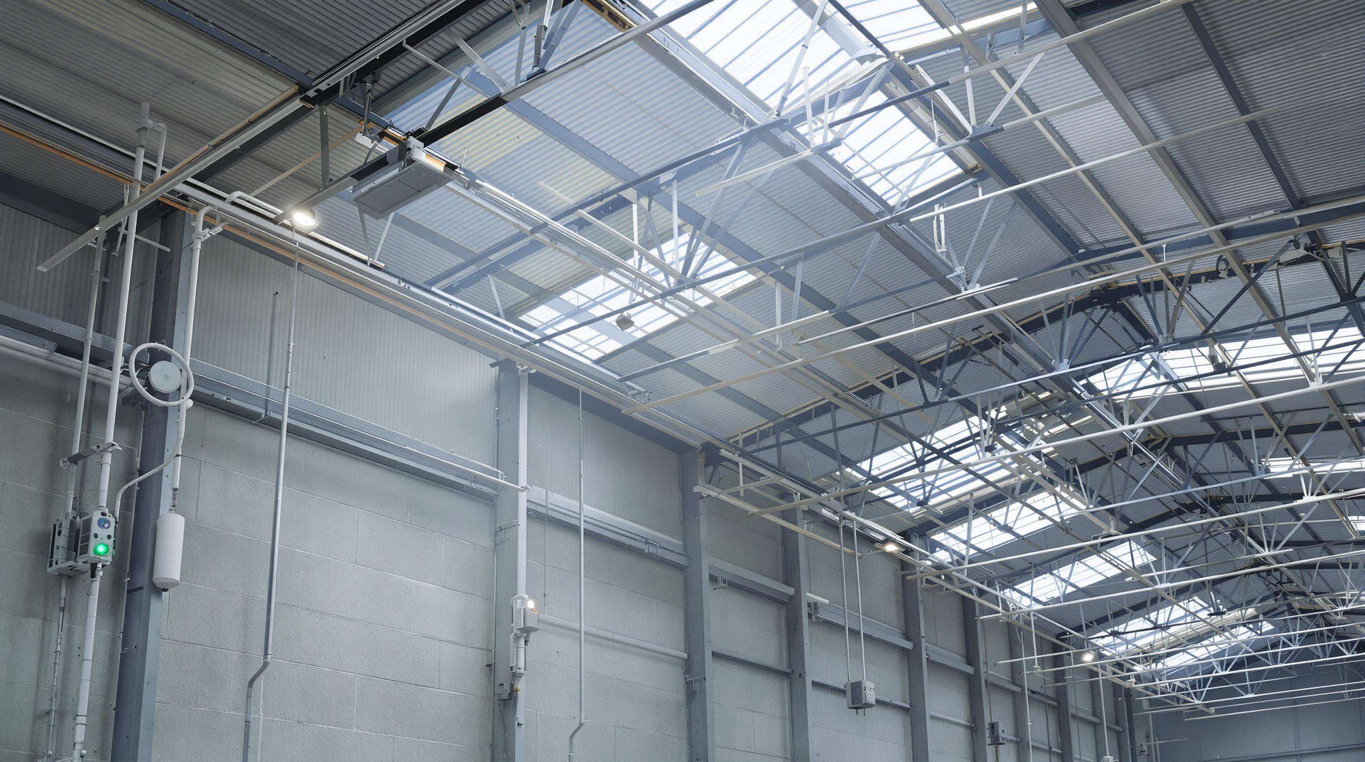 Warehouse with daylight streaming through windows and photoelectric sensors dimming LED lights