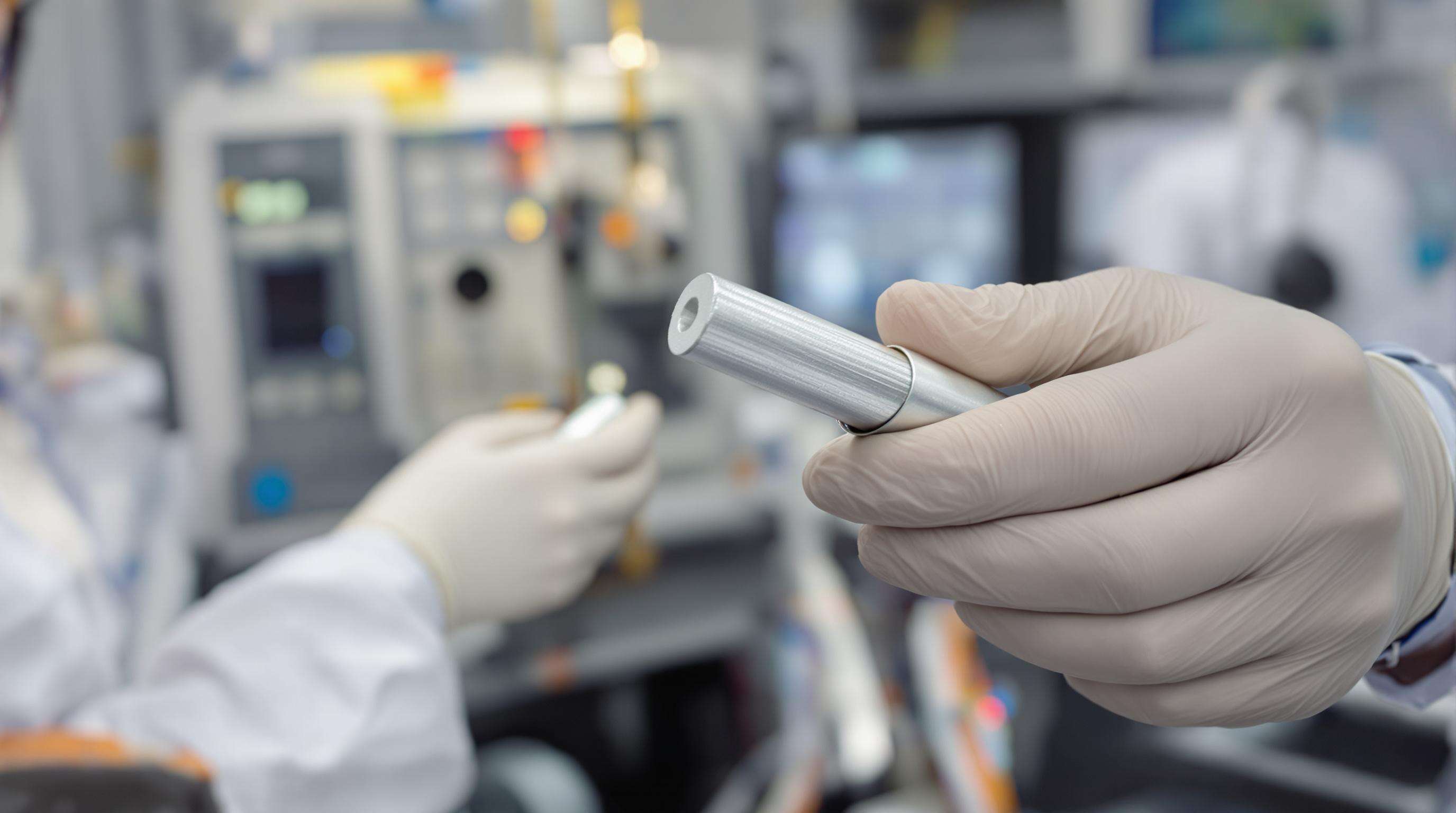 Technician examining an aluminum alloy power cable in a laboratory for strength and conductivity testing