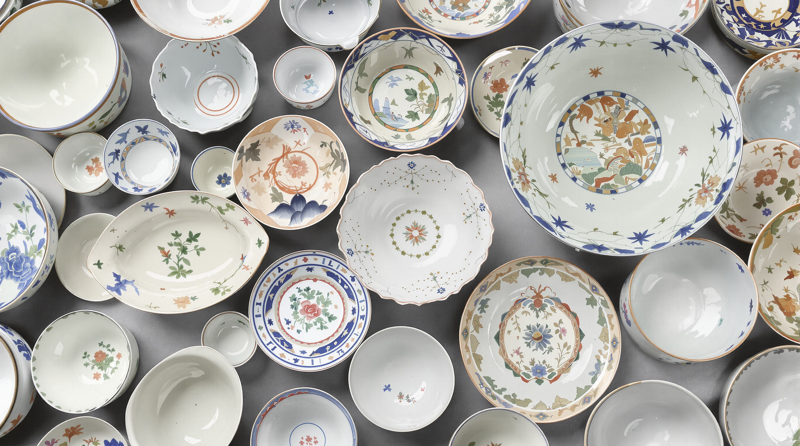 Assorted porcelain bowls of different sizes and shapes shown from above