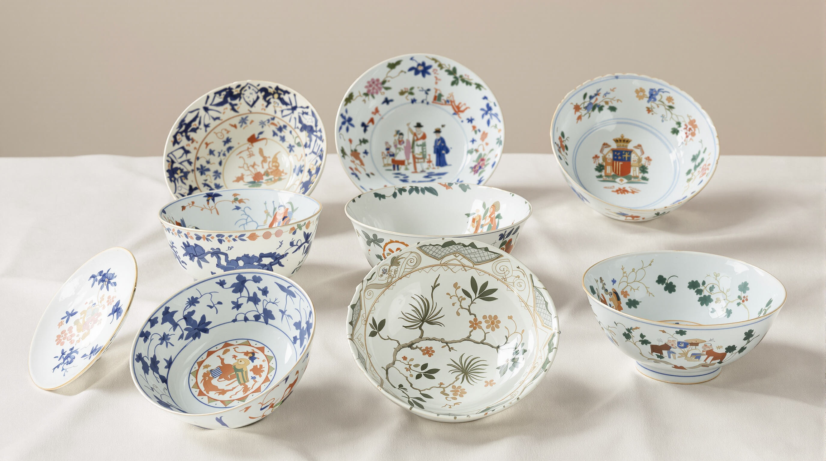 Porcelain bowls with varied decoration styles arranged on linen