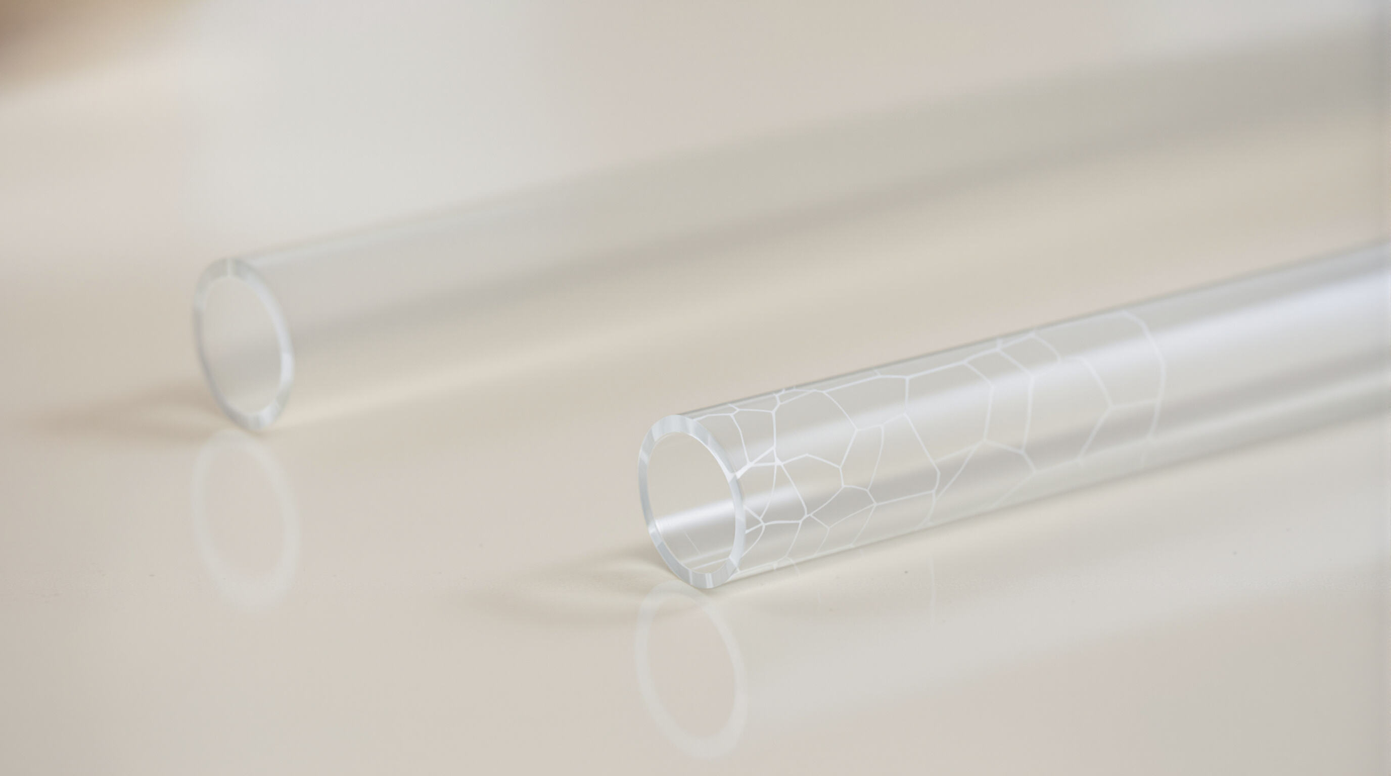 Pristine glass straw and cracked plastic straw side by side highlighting durability
