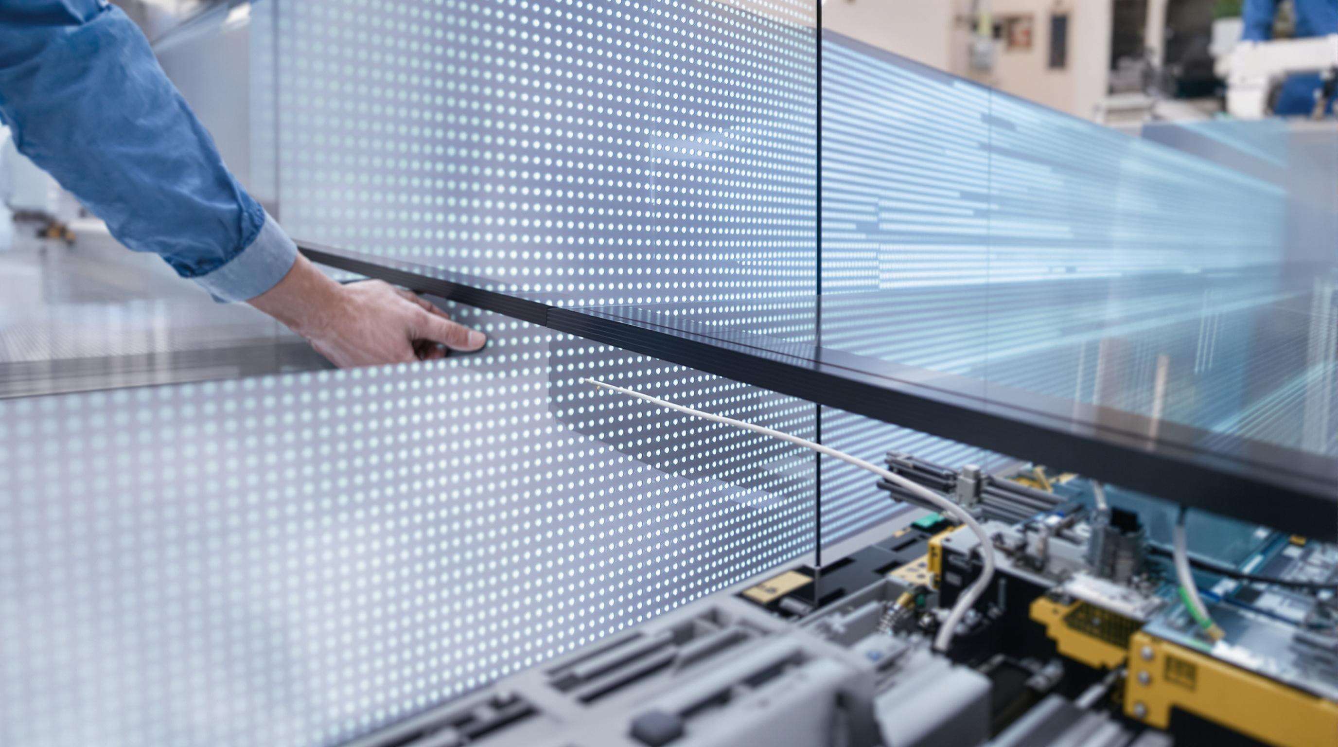 Technicians assembling seamless 0mm bezel LED display panels with precision in a modern control room