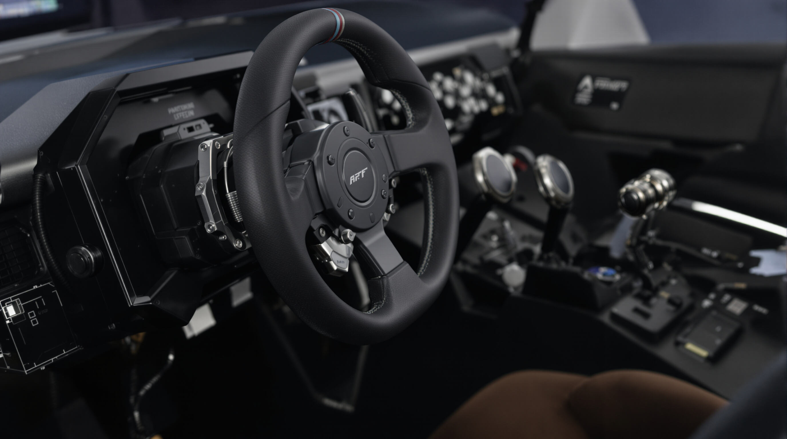 Close-up of advanced racing arcade controls including steering wheel, high-tech pedals, and a seat with visible electronics
