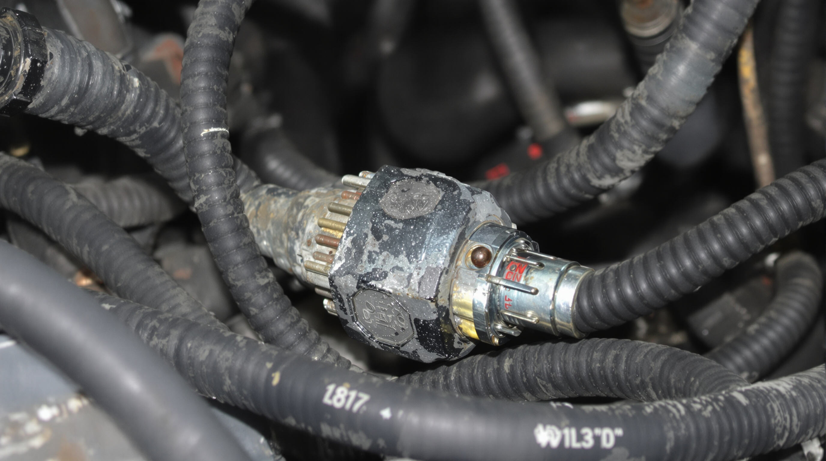Close-up of a rugged EV connector exposed to dust, moisture, and corrosion inside a vehicle