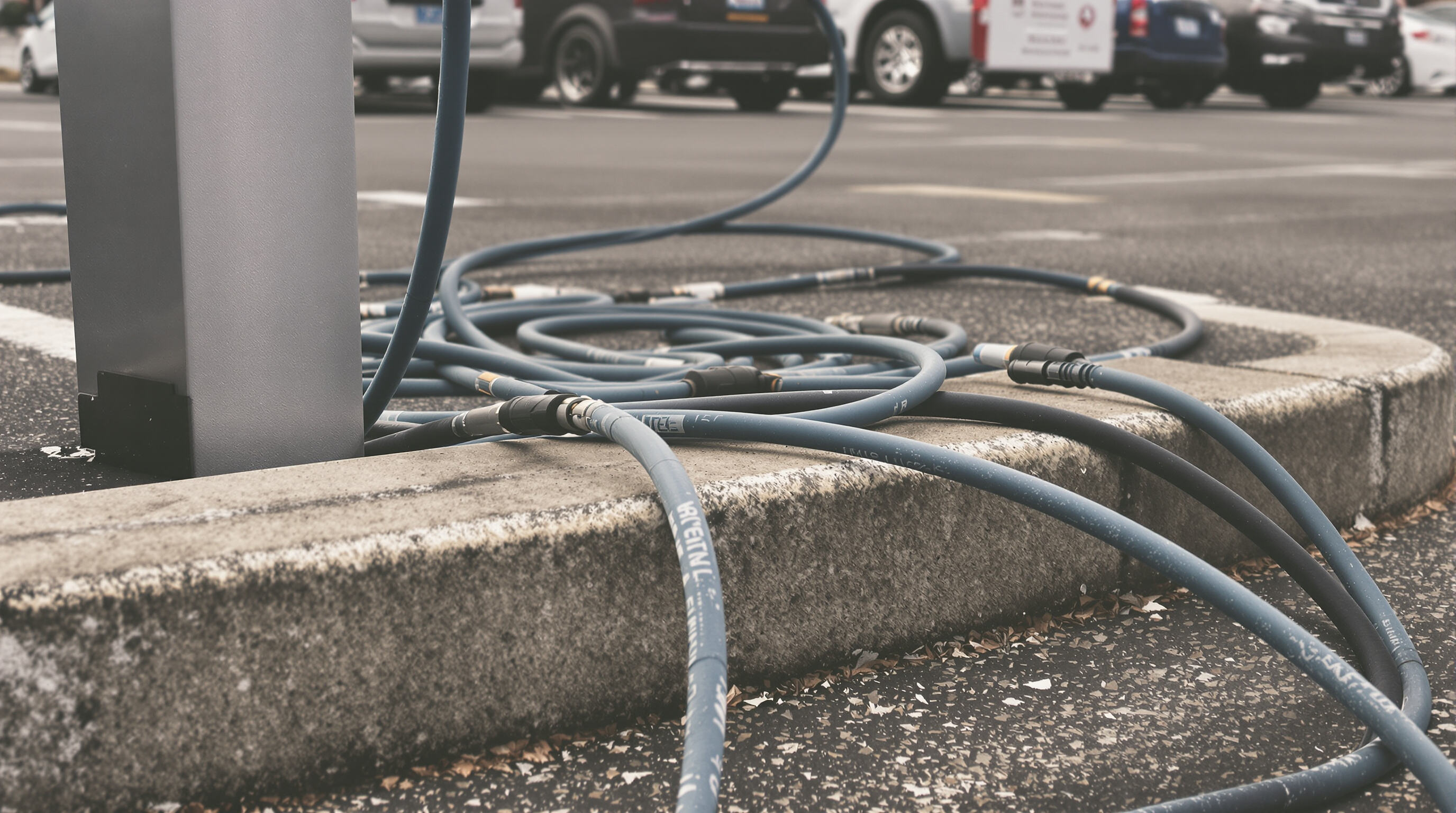 Photo of J1772 charging cables with bending and abrasion damage in a parking lot