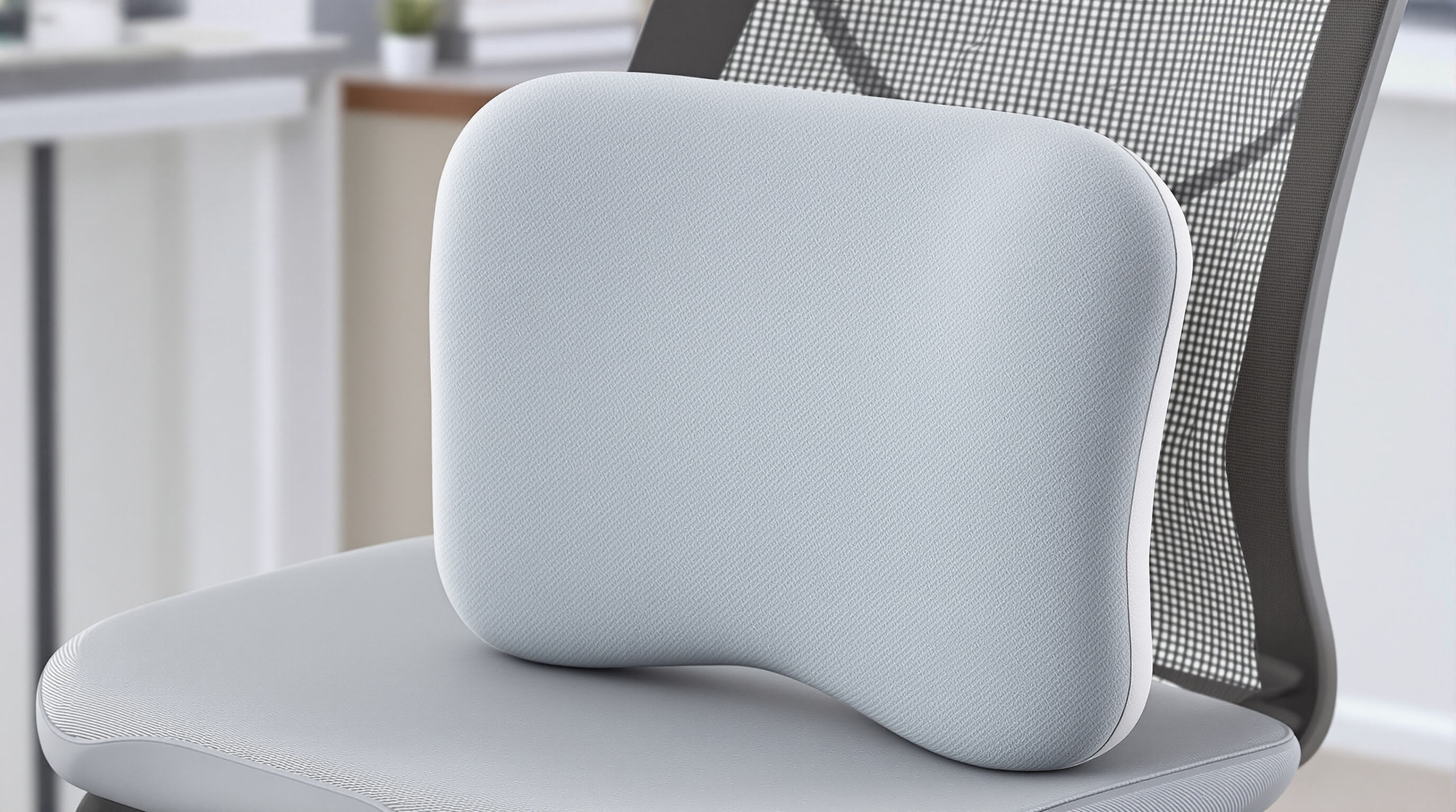 Modern portable lumbar cushion on a desk chair showing thin contoured ergonomic design