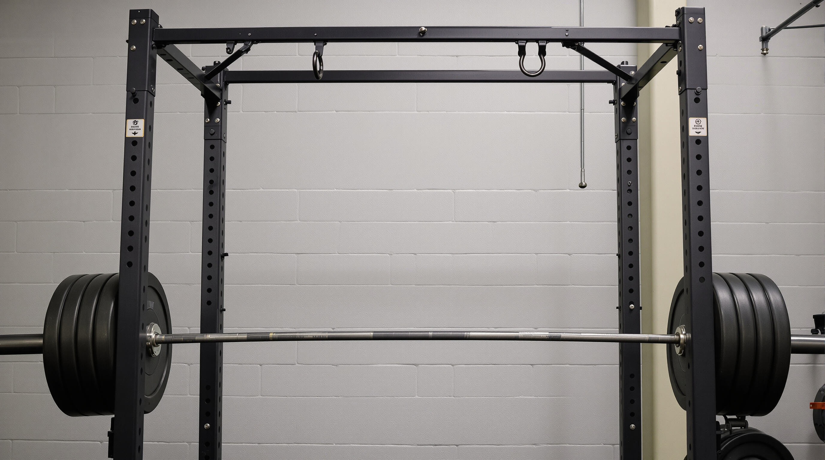 Squat rack in a gym with properly placed J-hooks and safety bars