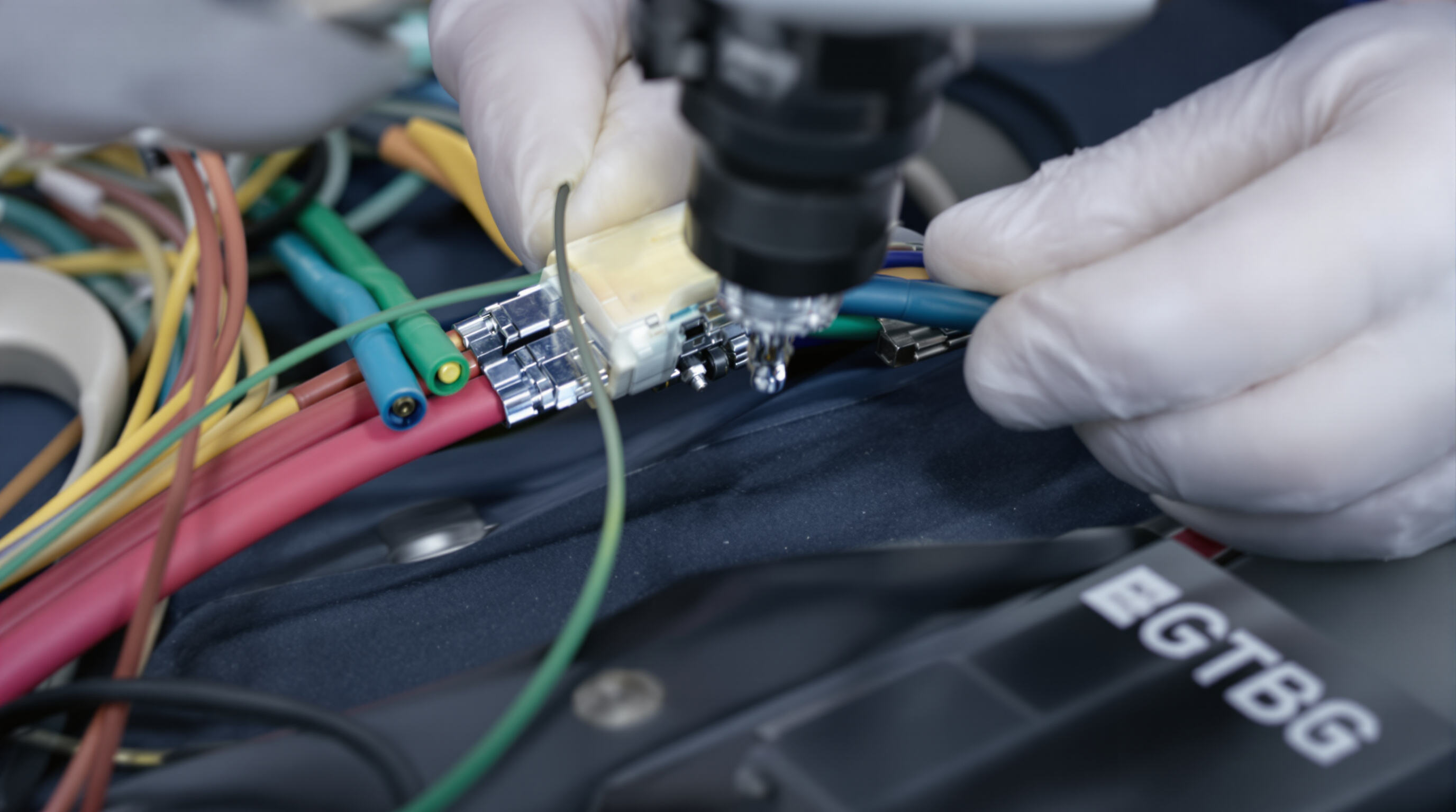Photorealistic image showing detailed inspection of ECG cable connectors and insulation for certification standards.