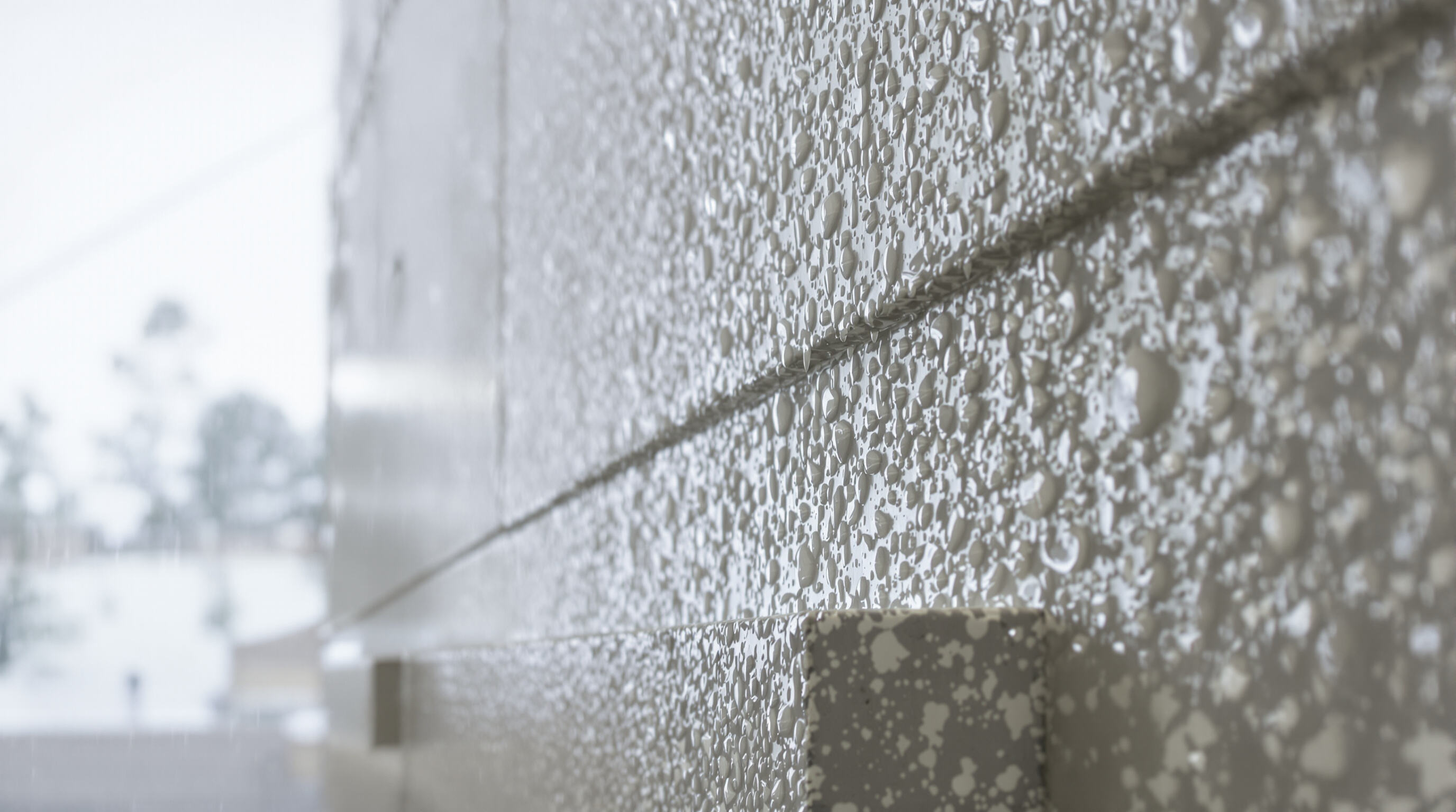 Rainwater beading and repelling off an ETICS mortar surface, illustrating water resistance