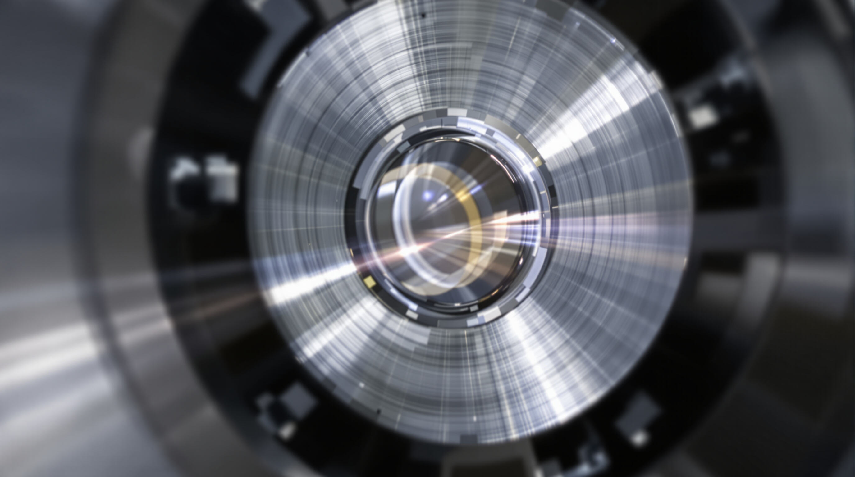 Close-up photo of a focusing lens within a fiber laser cutting machine, showing its material and precise mounting.