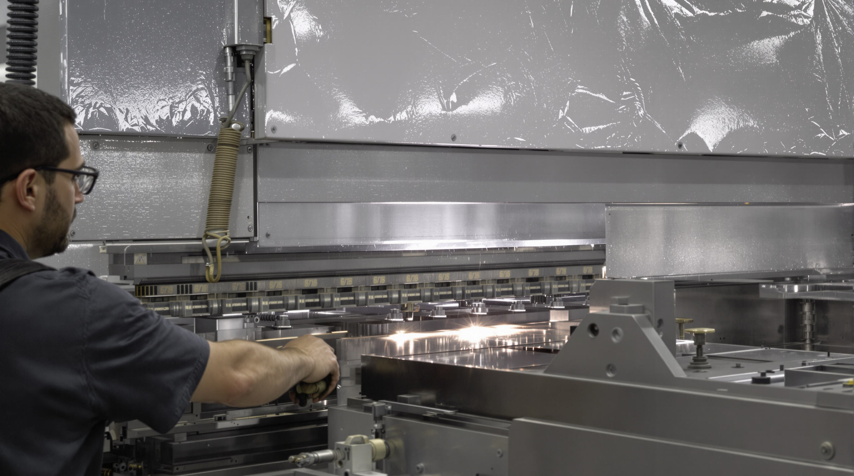 Press brake operator maintaining safe hand position near active metal bending machine