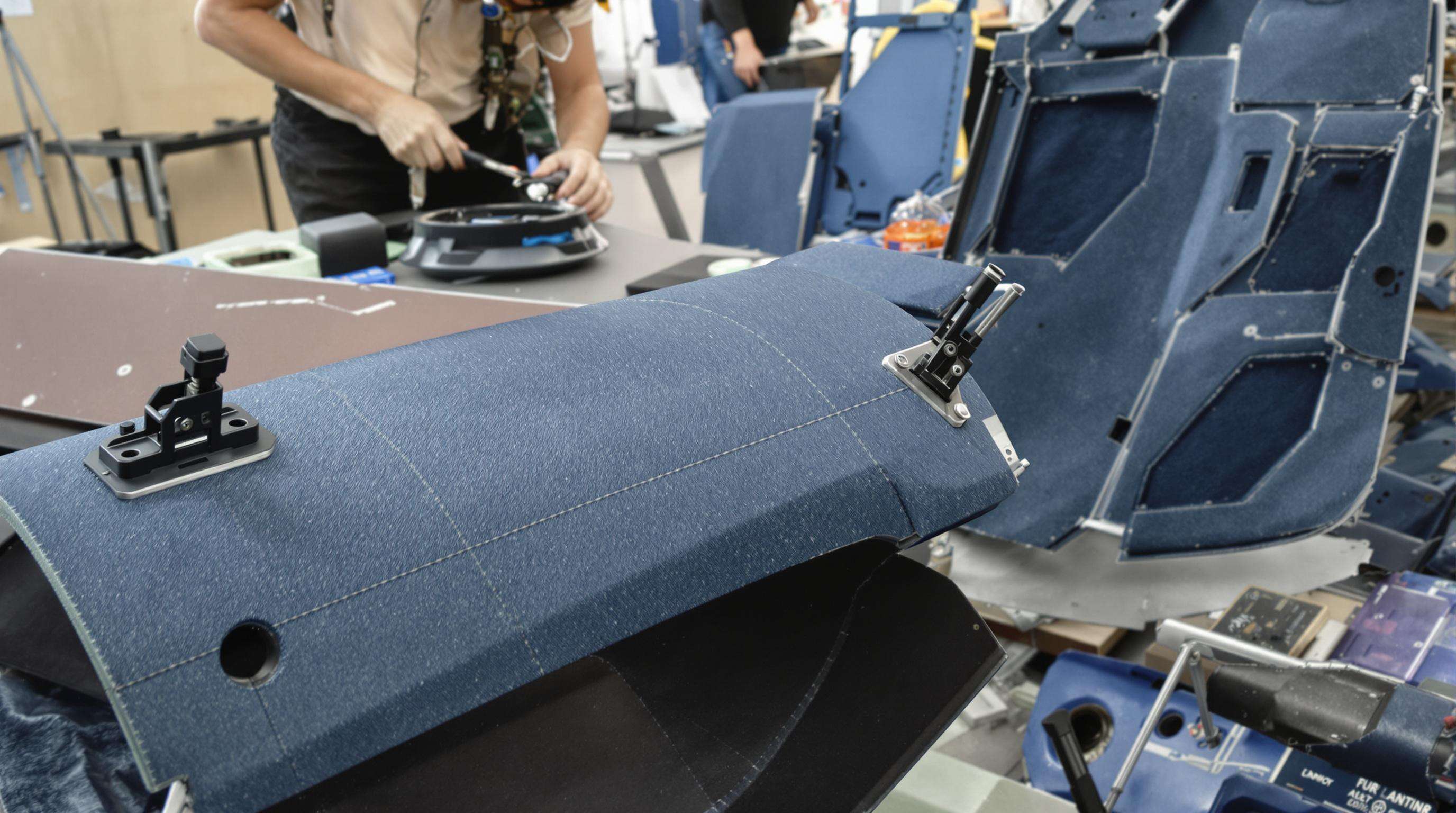 Automotive workshop assembling parts from recycled ocean plastics and upcycled denim for car interiors.