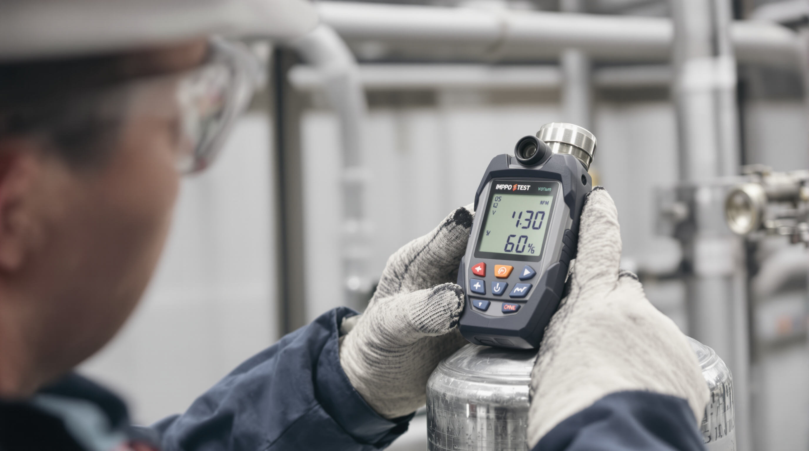 Technician conducting bump test with a gas detector and canister in an industrial setting