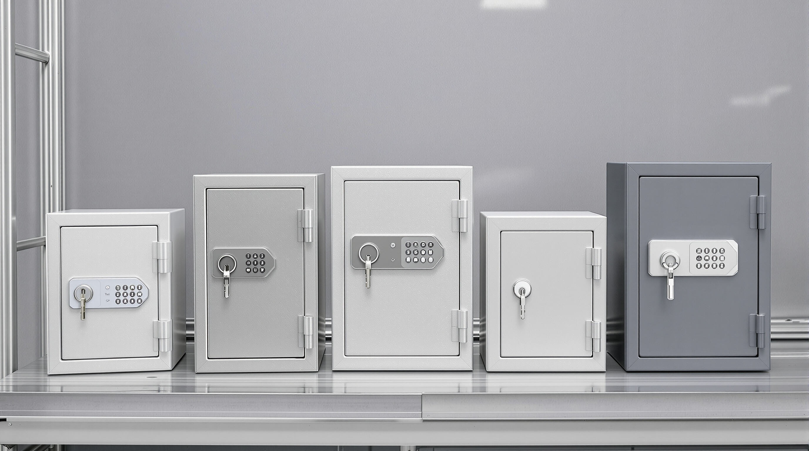 Close-up photo showing stainless steel, alloy, and composite polymer key safe lock boxes side by side, highlighting different materials and textures.