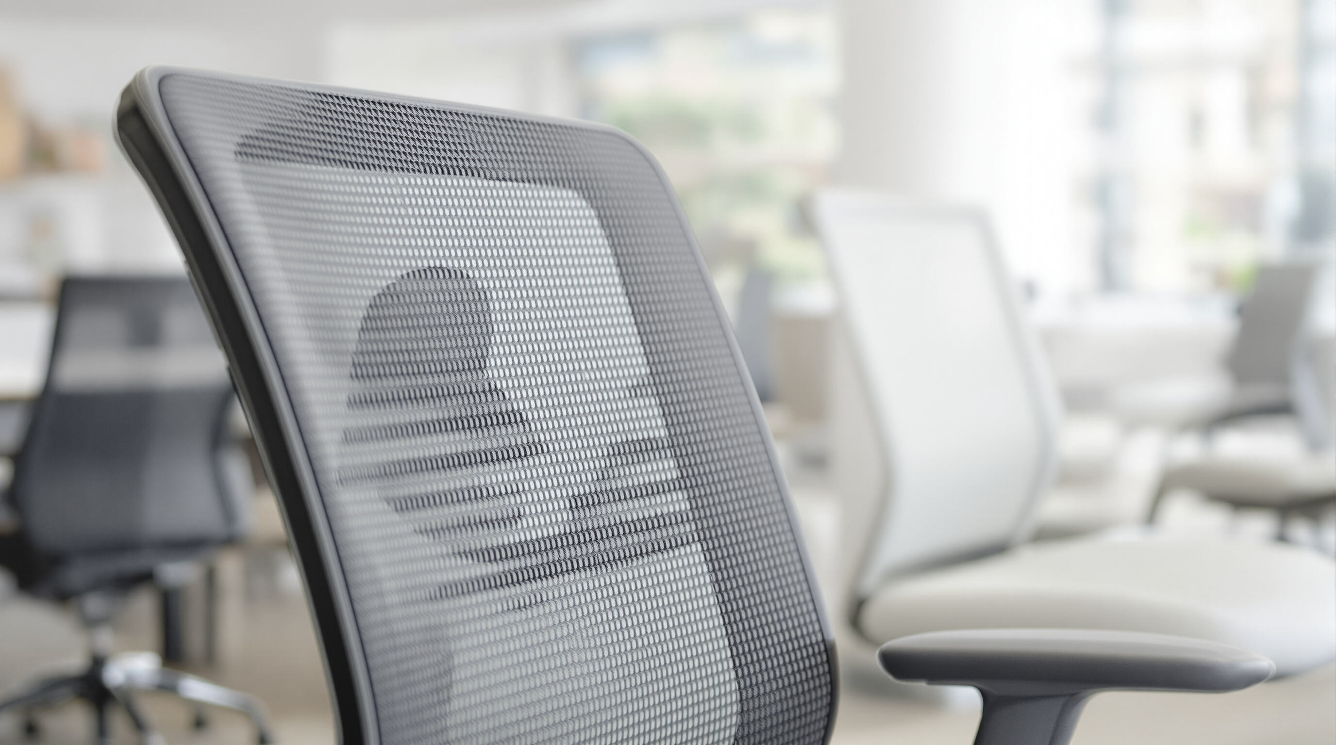 Photorealistic close-up of a mesh office chair highlighting ventilated materials and airflow