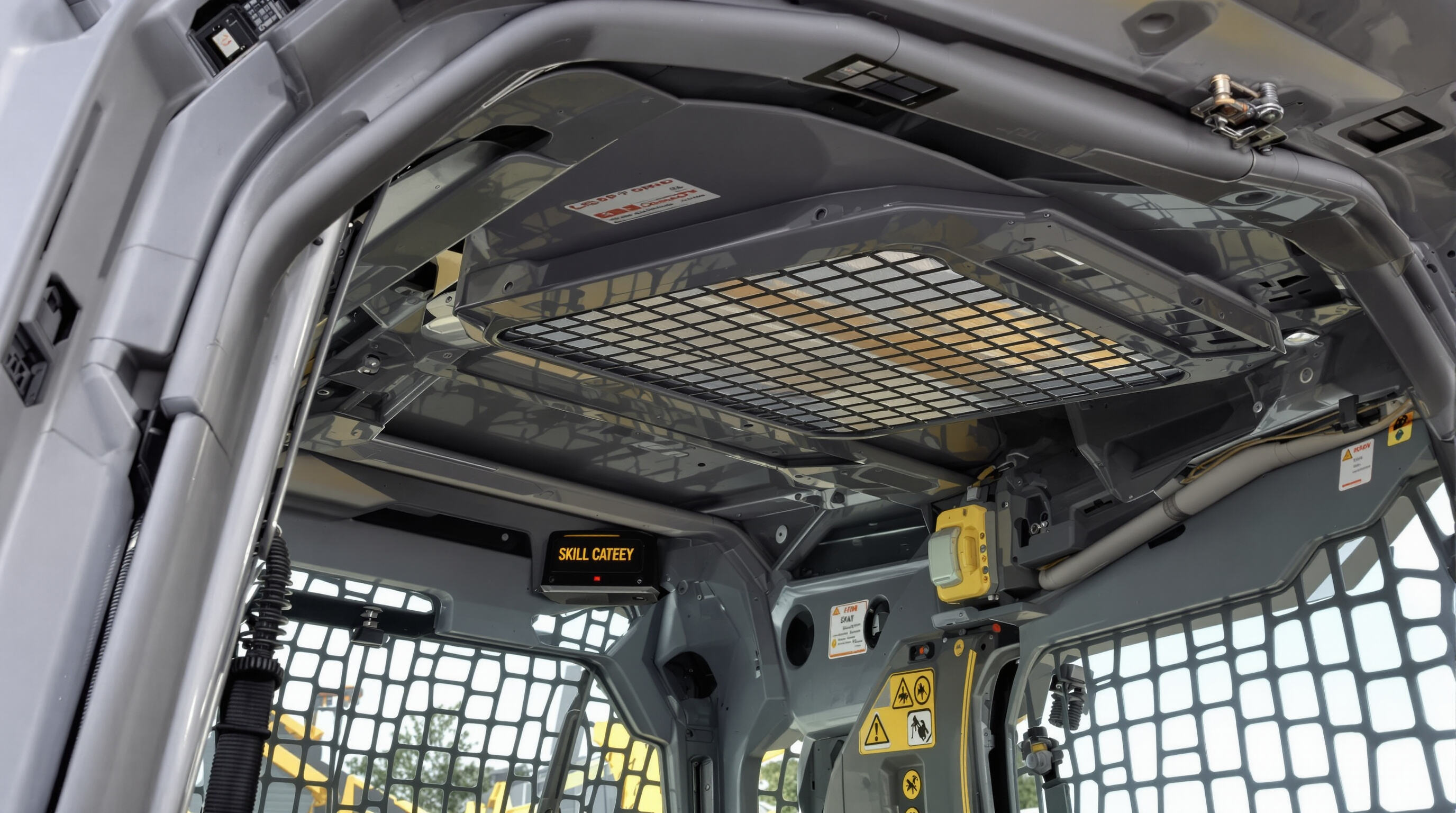 Close-up view of skid steer cab with roll-over protective structure, seat belt, and overhead mesh demonstrating built-in safety systems