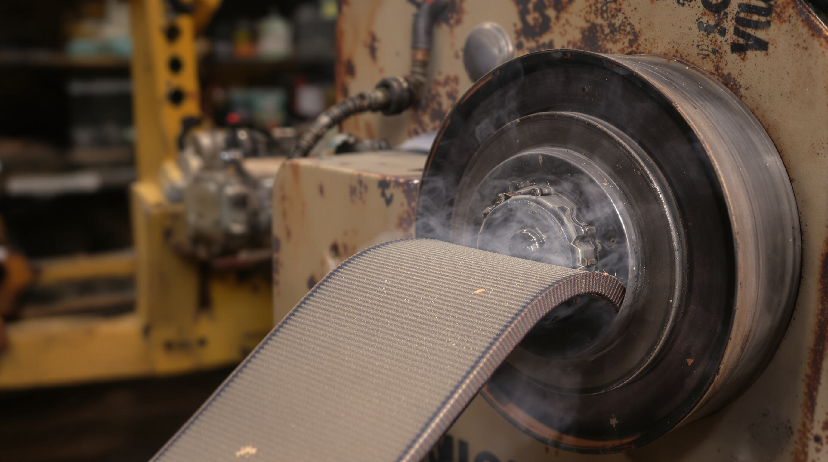 Close-up of misaligned wood chipper belt and pulley with signs of wear