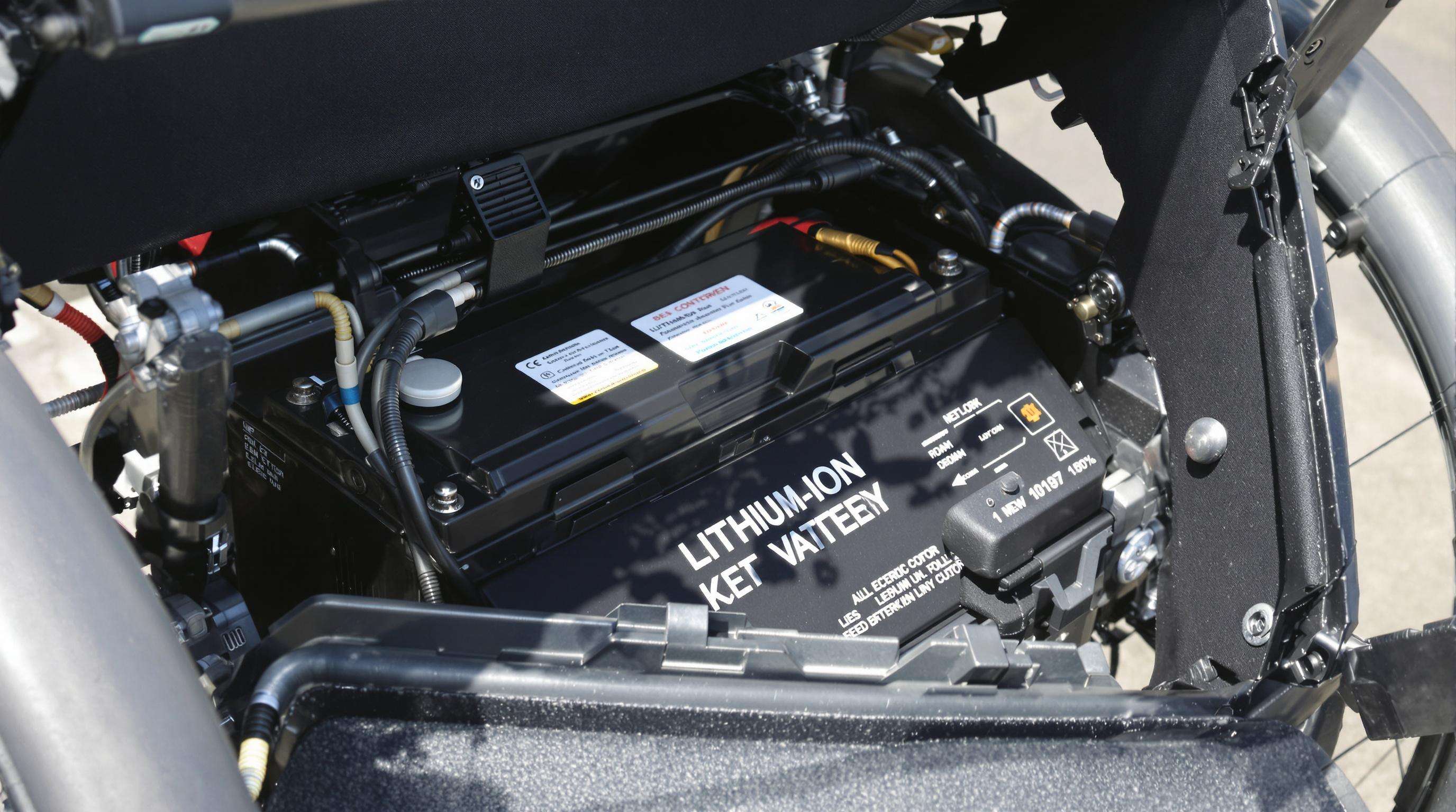 Close-up of a modern electric wheelchair’s lithium battery and integrated solar panel details in soft daylight