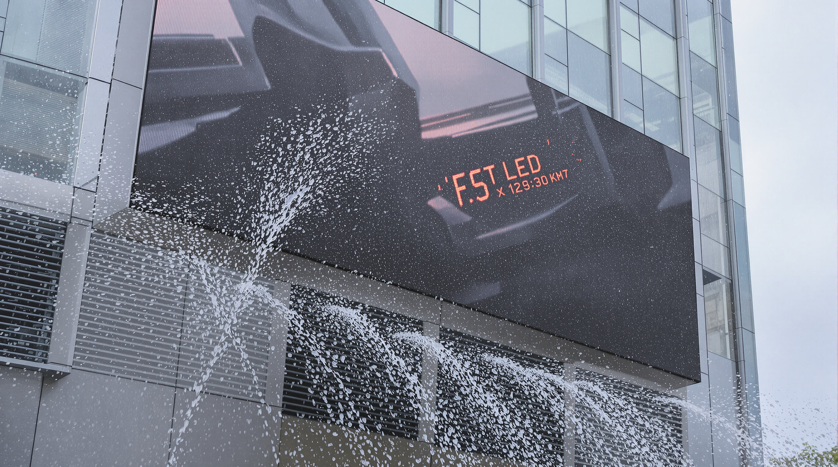 Outdoor LED display enduring heavy rain and dust, showing weatherproof enclosure features