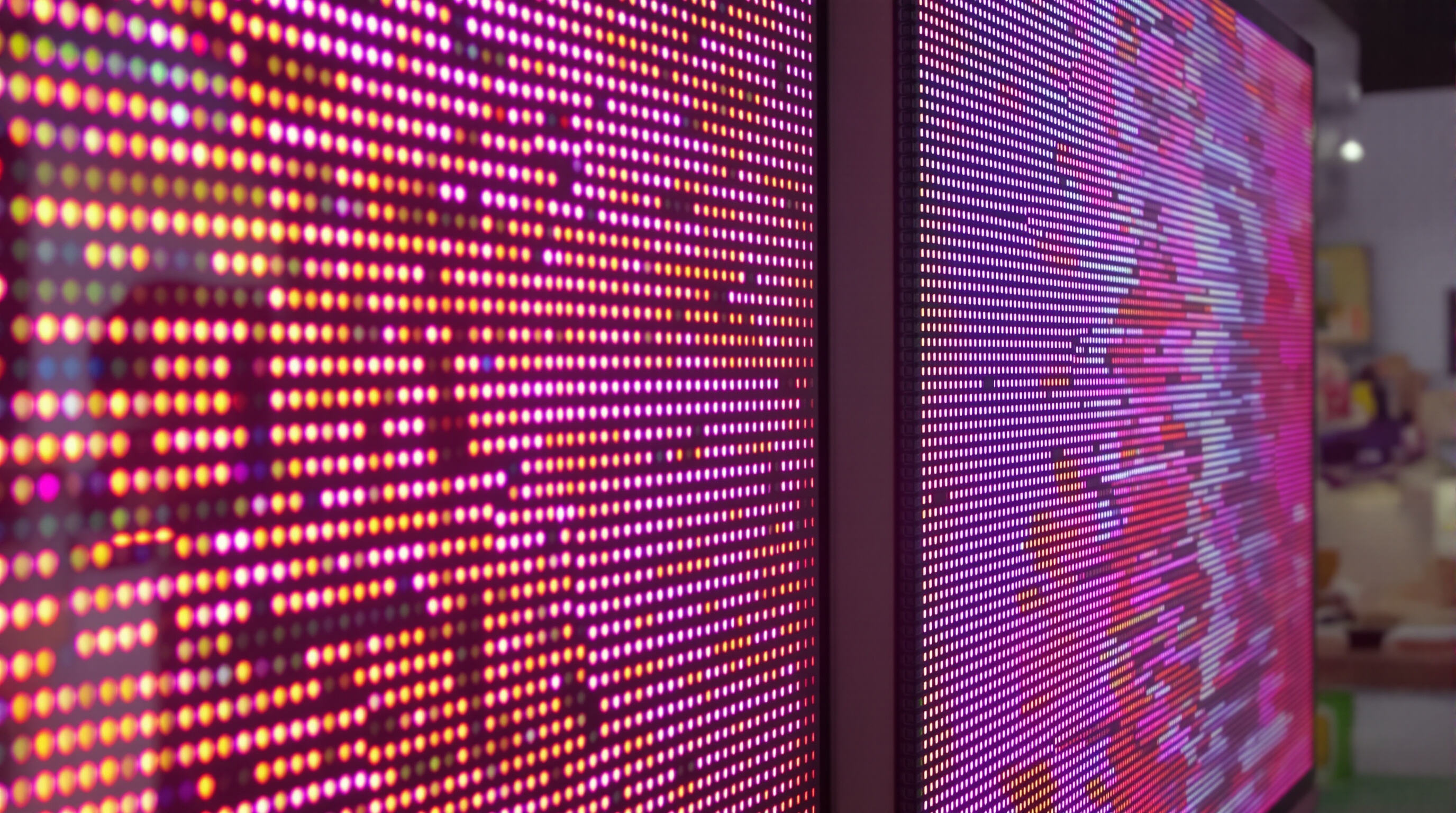 Close-up comparison of two LED screens, one with fine pixel pitch showing clear details, the other with wider pitch and less sharpness