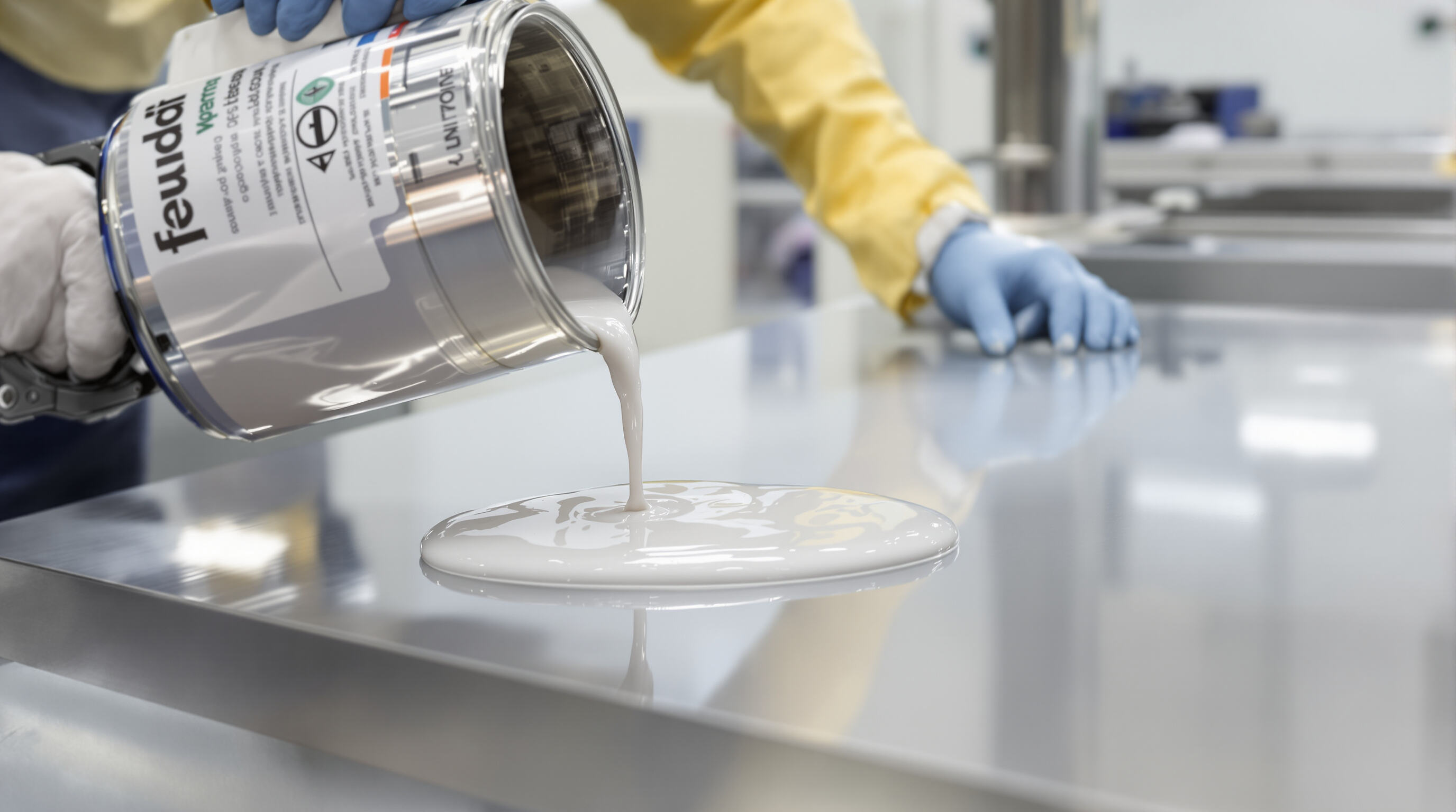 Technician pouring epoxy coating as the liquid levels smoothly on a metal panel in a lab setting