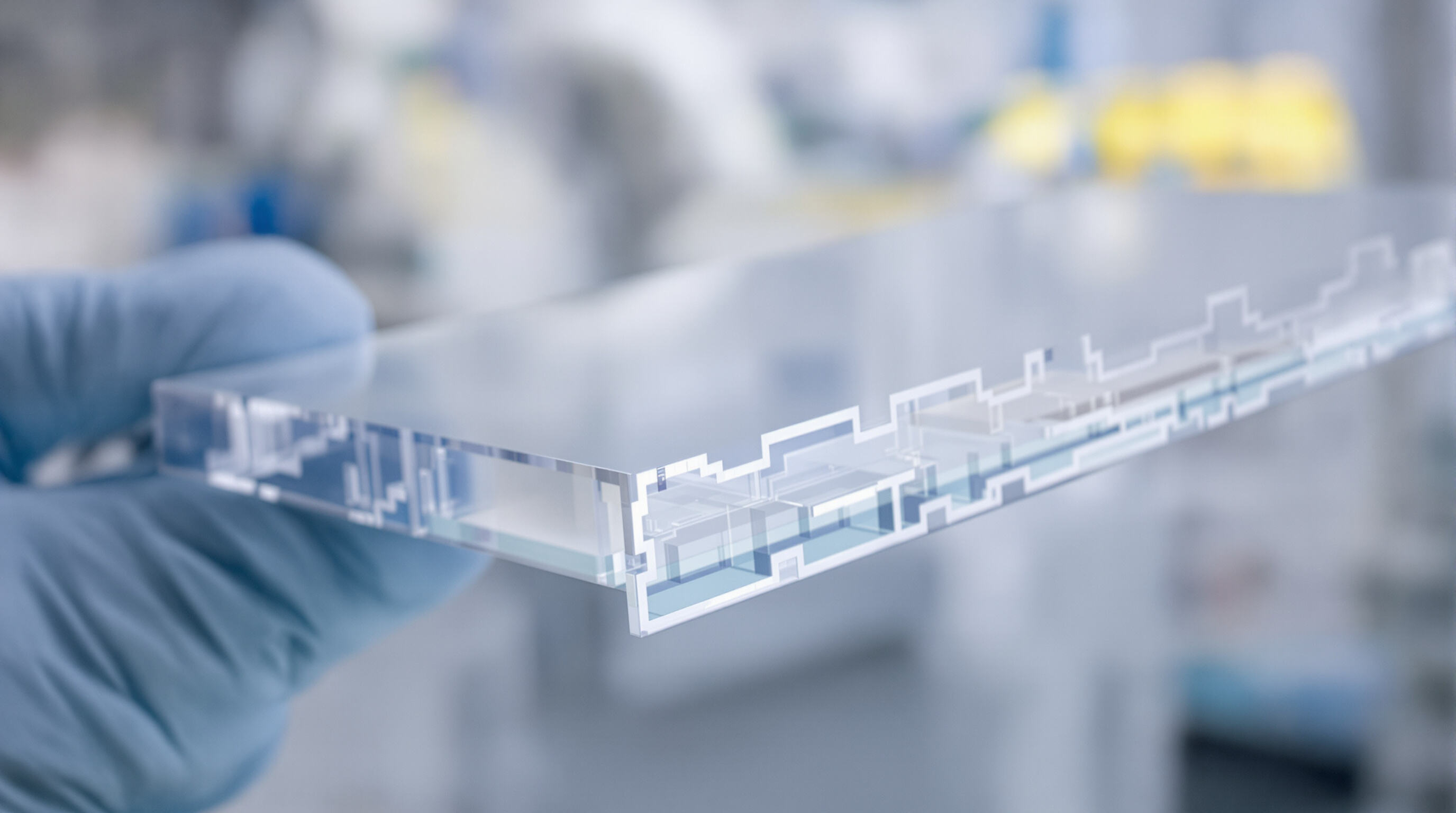 Close-up of a transparent polycarbonate sheet held by a gloved hand, highlighting clarity and structural details in a lab environment