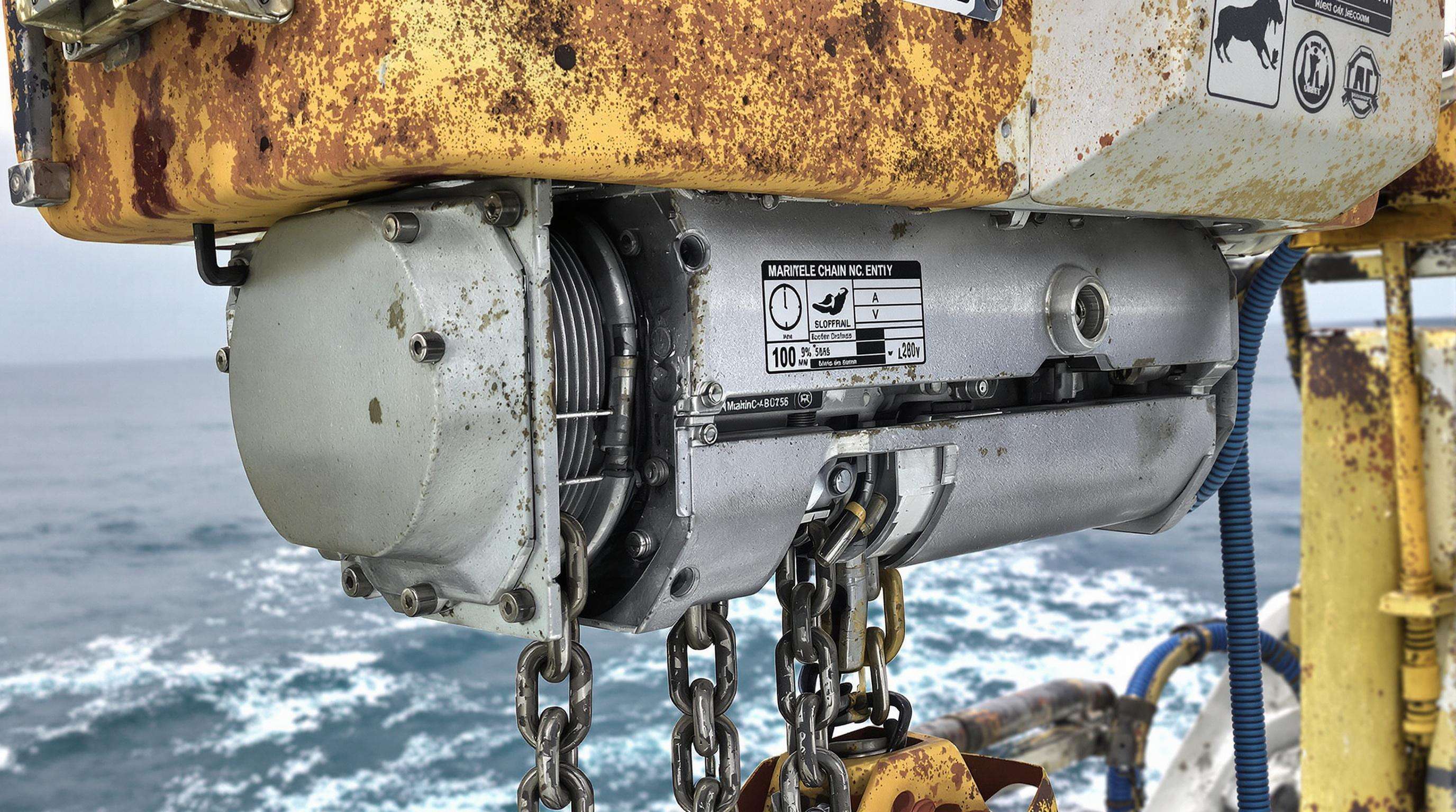 Heavy-duty electric chain hoist near the ocean with corrosion-resistant components exposed to moisture