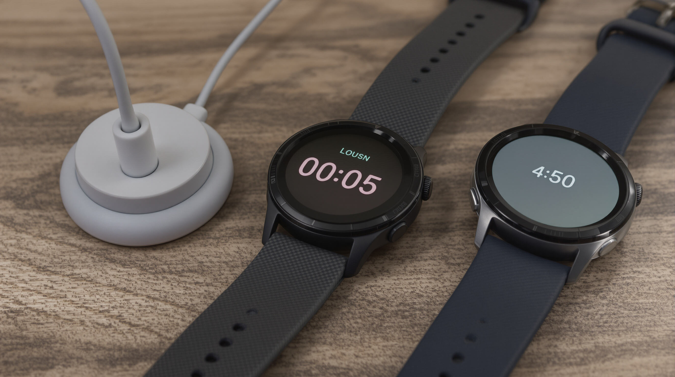 Three smartwatches illustrating charging, active use, and power-saving modes on a wooden surface