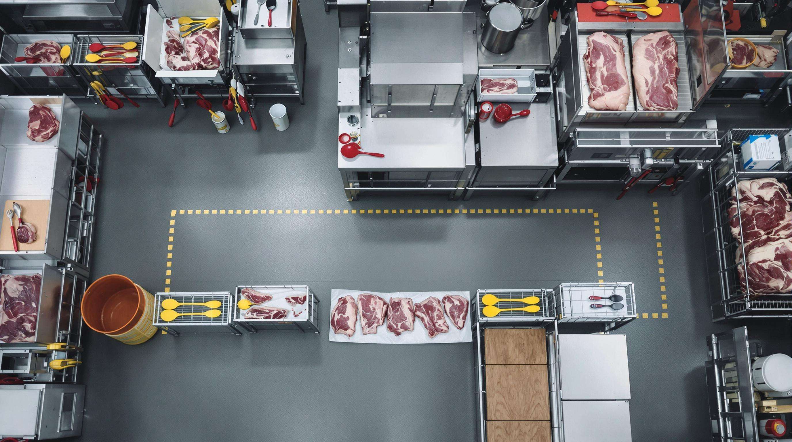 Overhead view of a meat processing plant with separated zones and color-coded tools to prevent cross-contamination