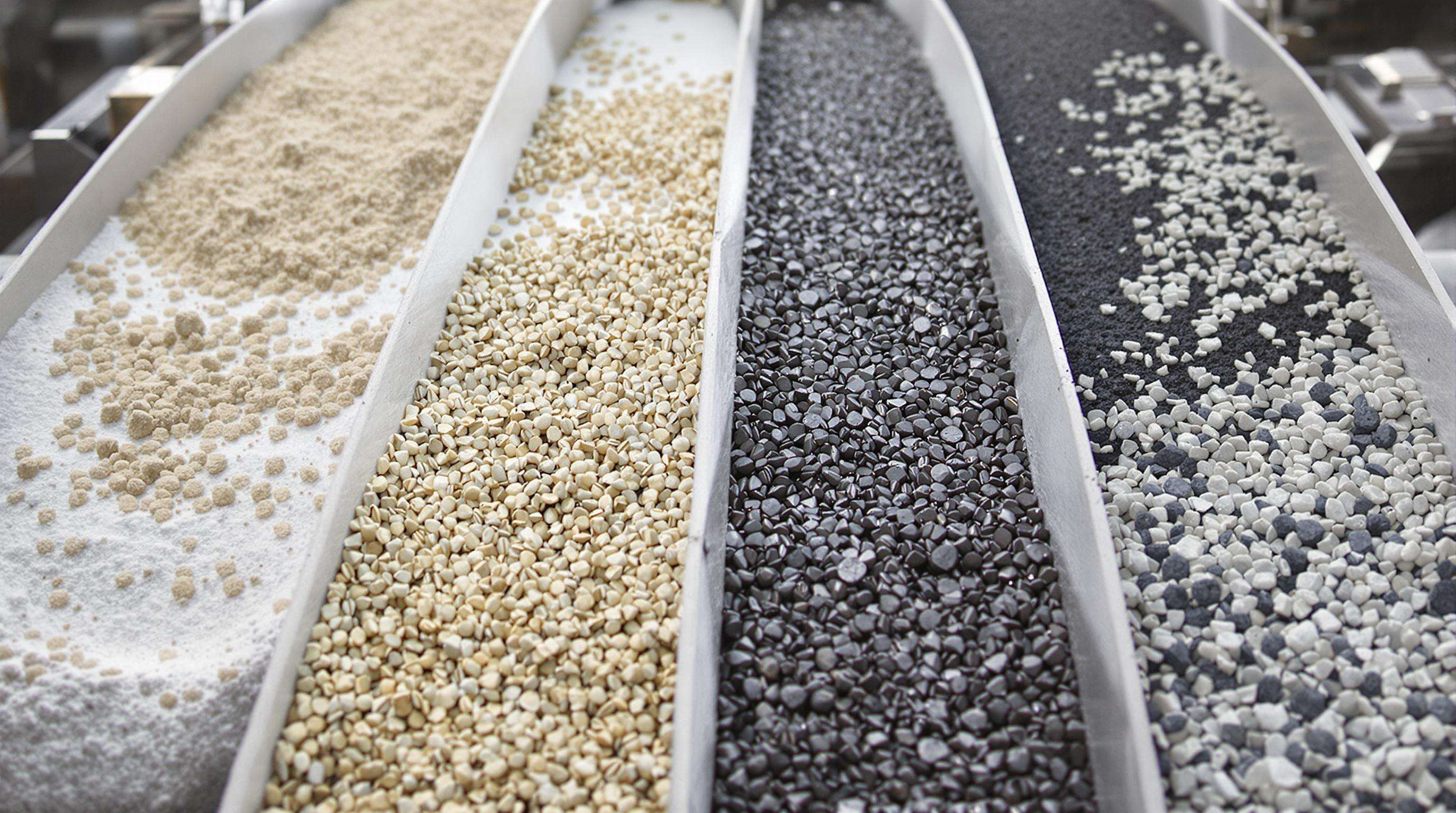 Close-up of varied materials—powder, granules, solids, and slag—each on a different industrial conveyor
