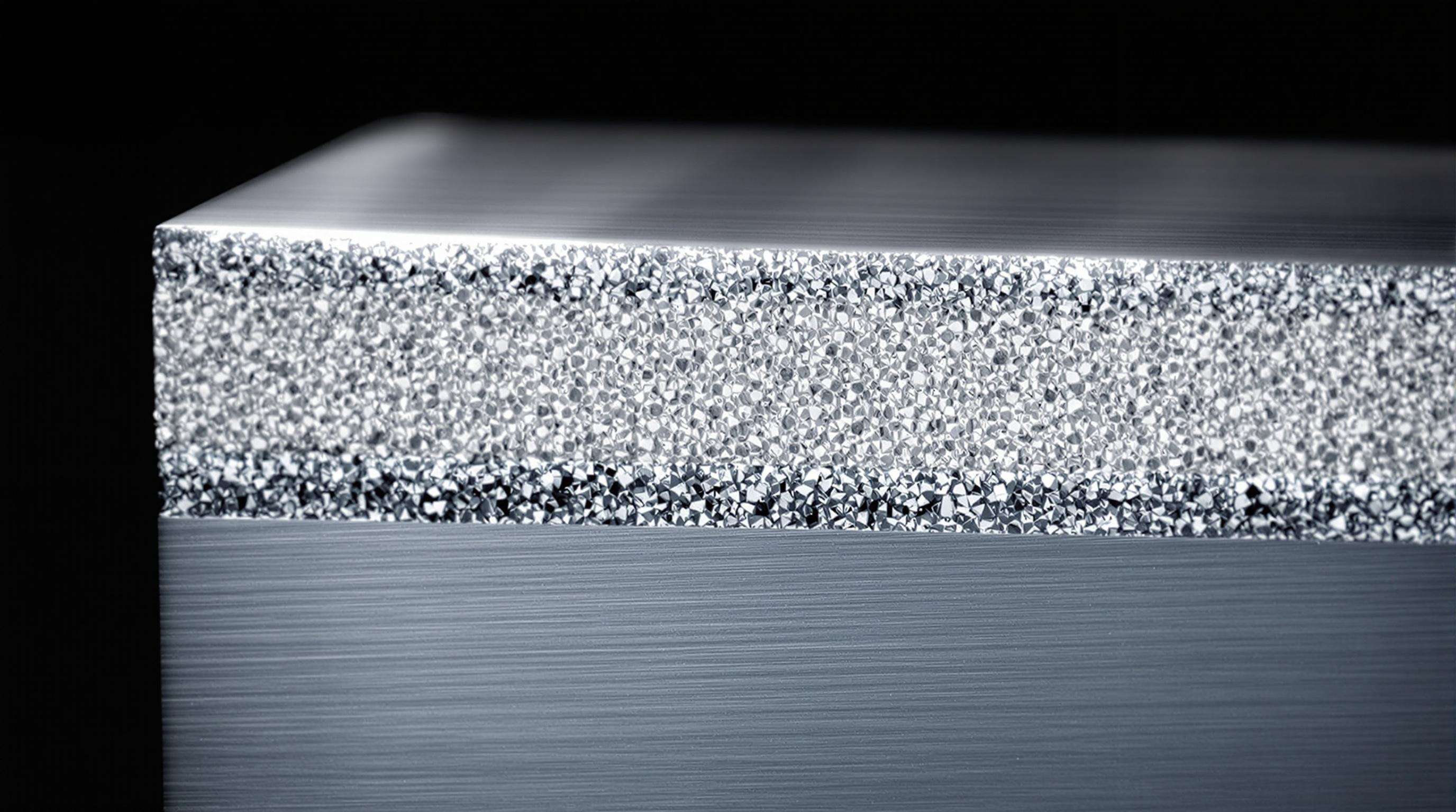 Close-up cross-section of a metal matrix composite showing metal base with embedded ceramic particles
