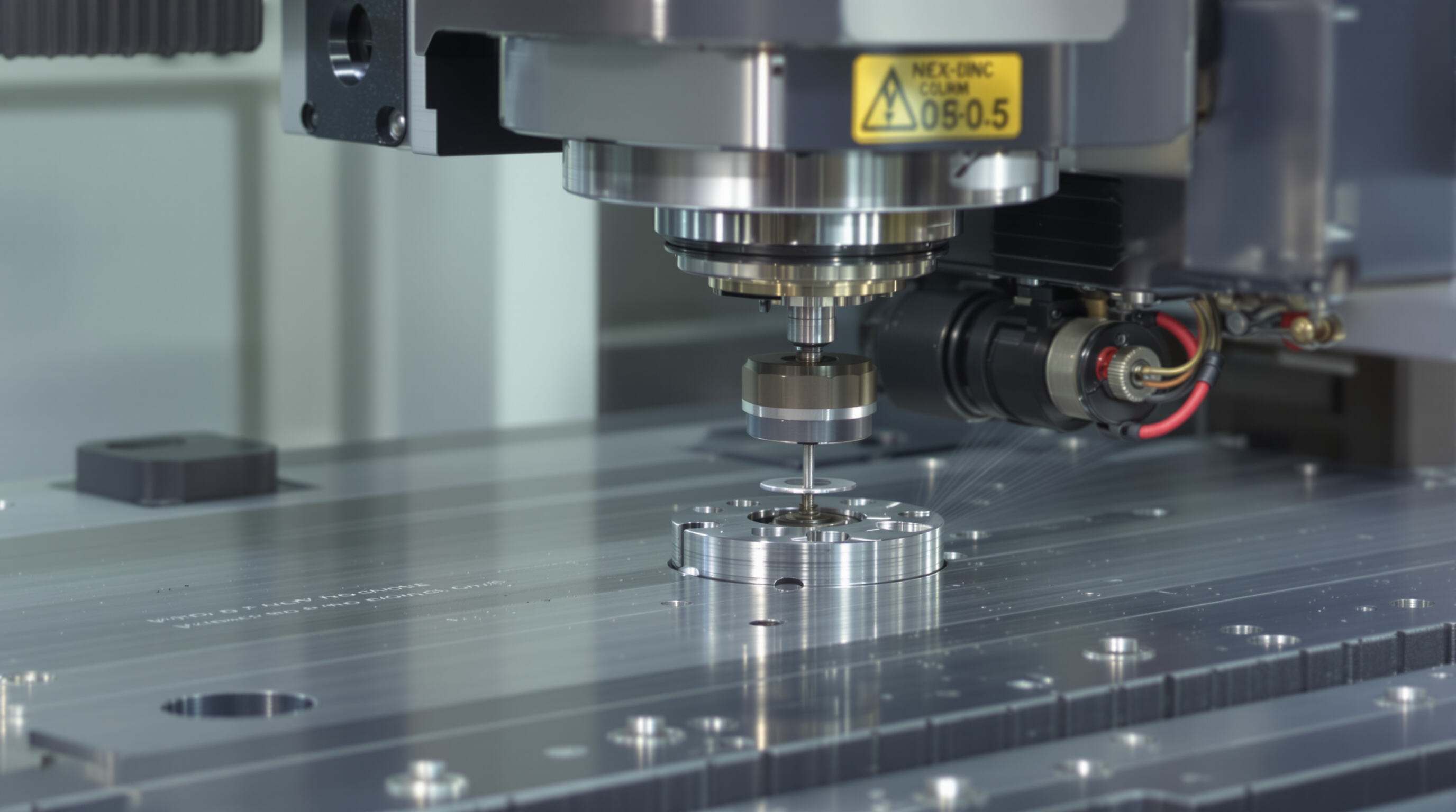 Close-up of a 5-axis CNC milling machine precisely machining a complex metal part with advanced sensors visible.