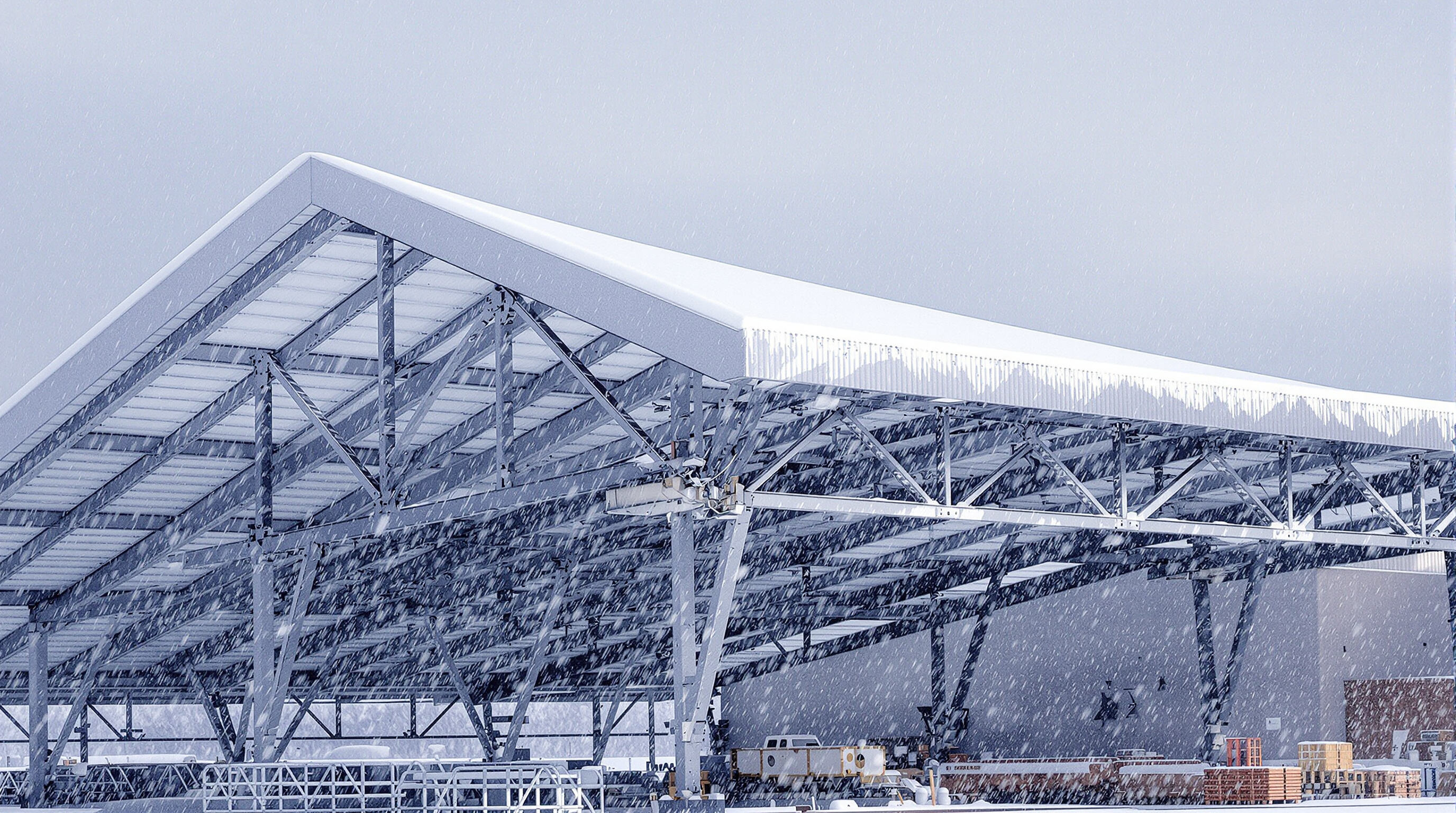 A durable car shelter with steel frame and snowy roof, showing reinforced structural supports in wintry weather