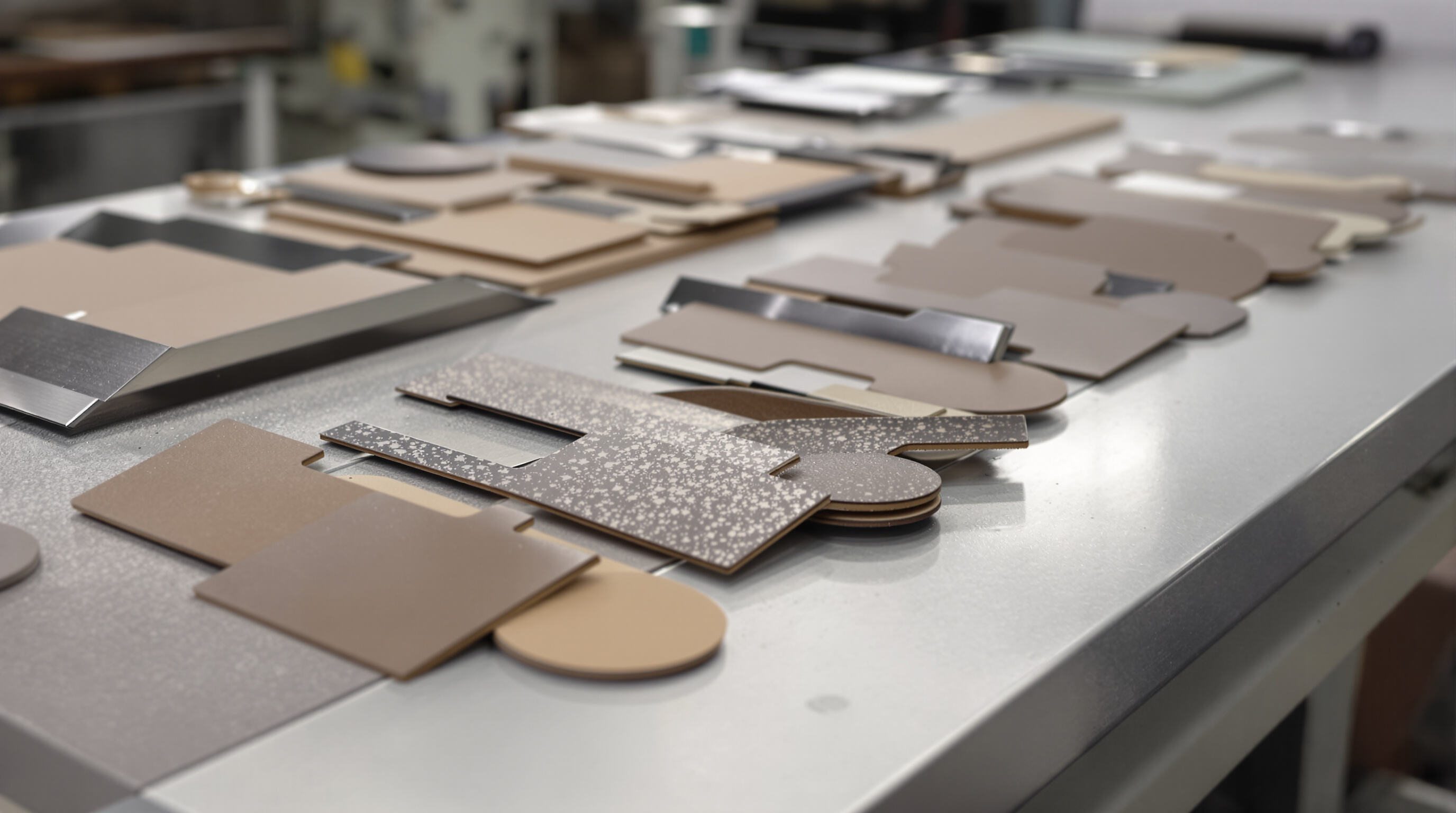 Precisely cut metal and leather parts displayed on a worktable, highlighting accuracy and reduced material waste.