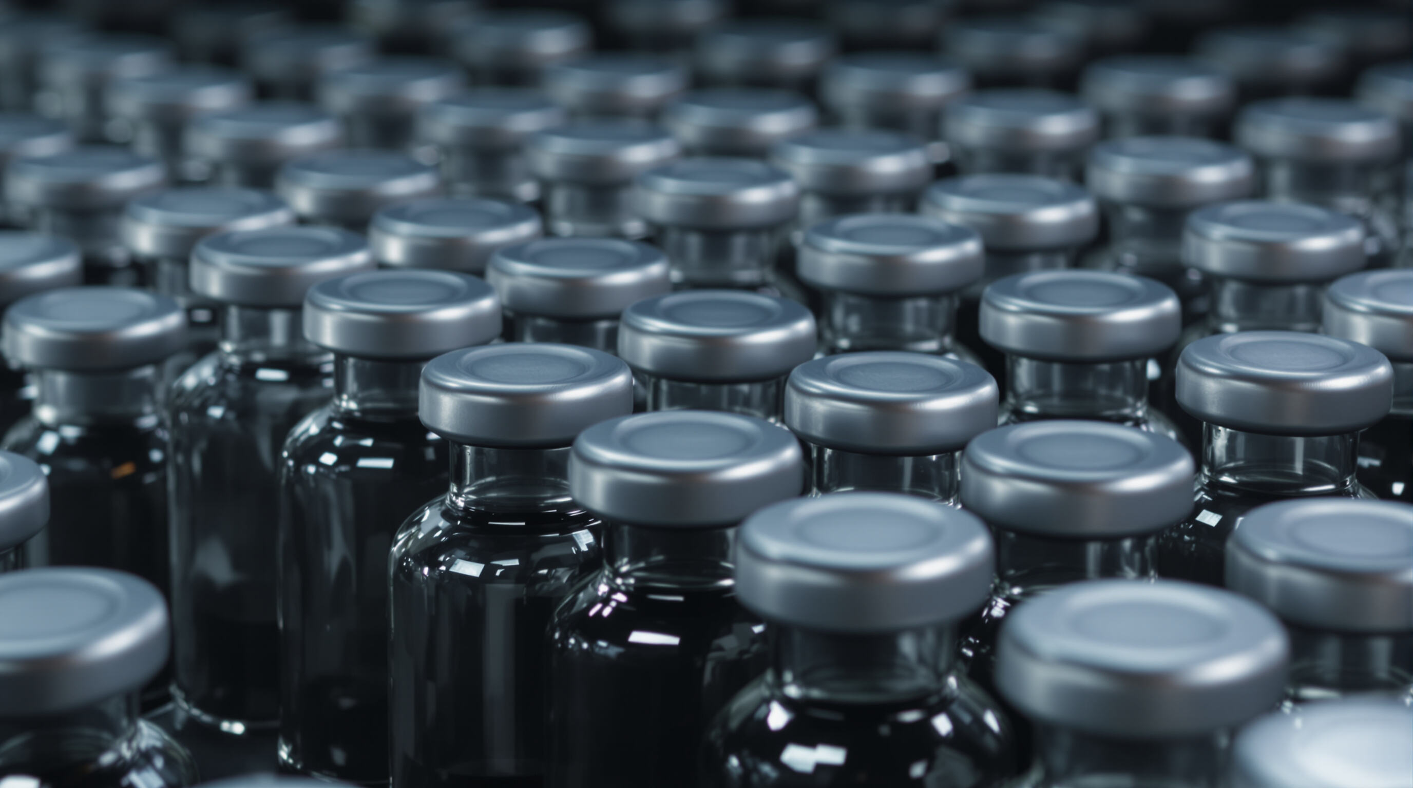 Opaque sealed ampoule serum vials made of dark glass and metallic materials arranged upright in a studio setting
