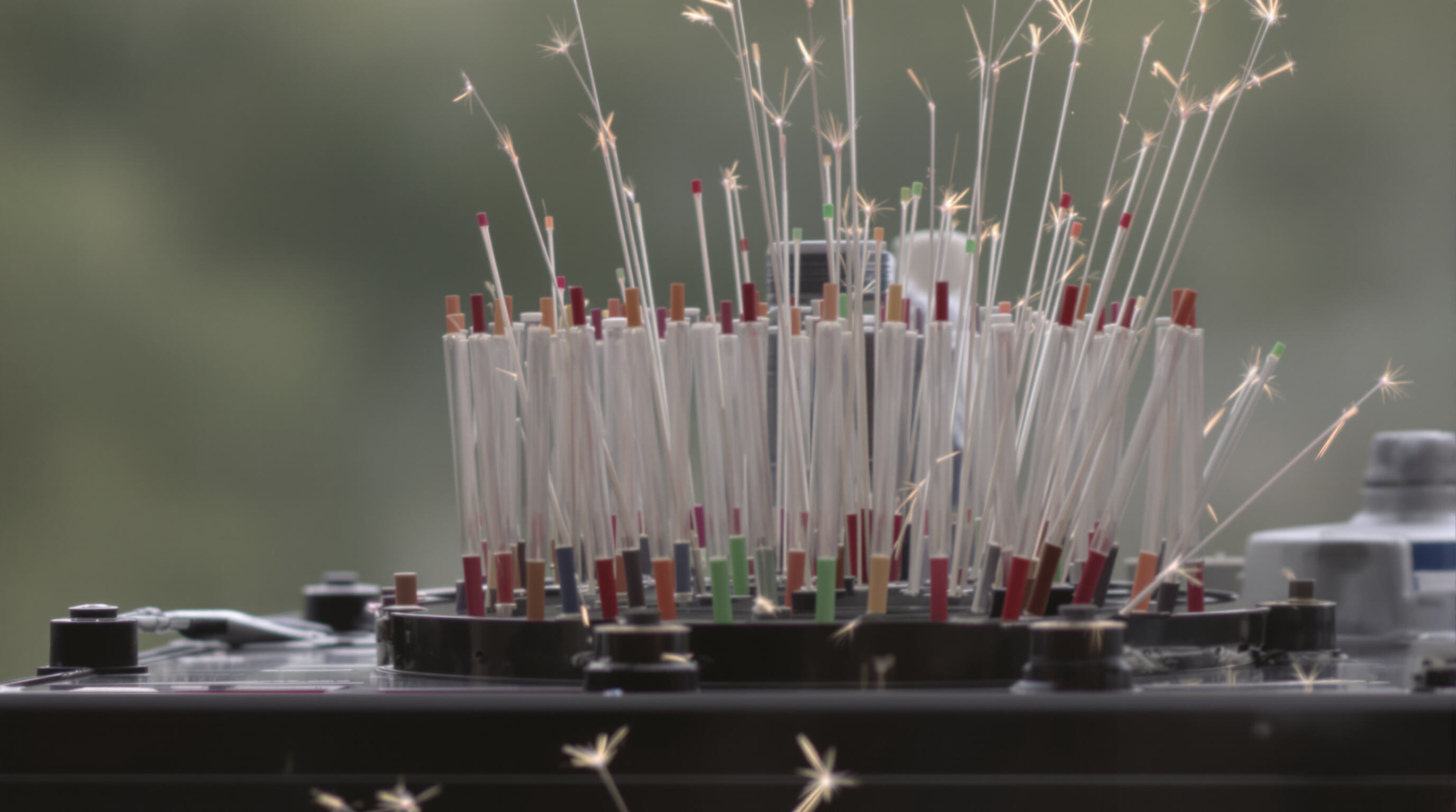 Close-up of a multi-tube cake firework device showing tubes and fuses on a fireproof base