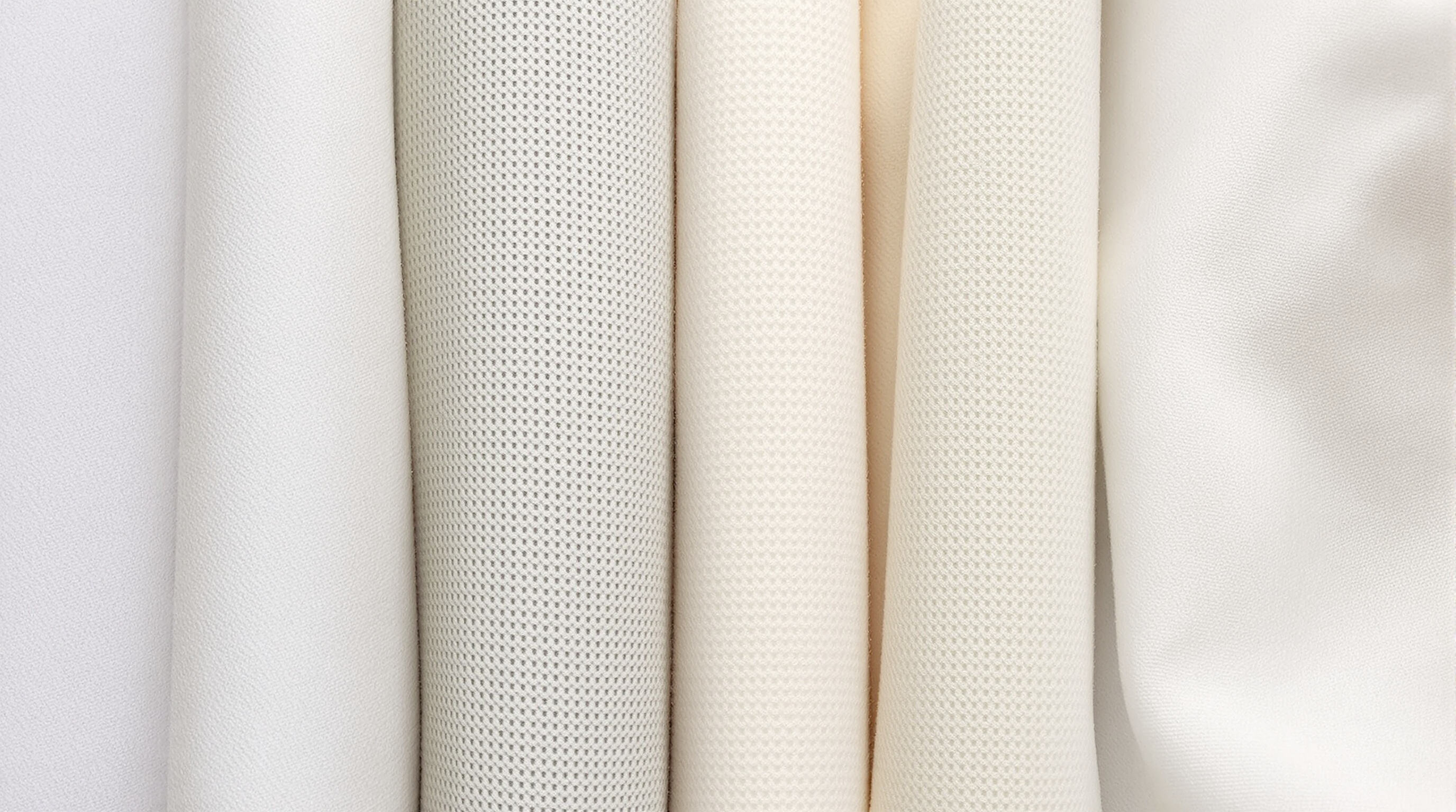 Macro close-up of various hypoallergenic fabric swatches showing tight weaves and soft textures