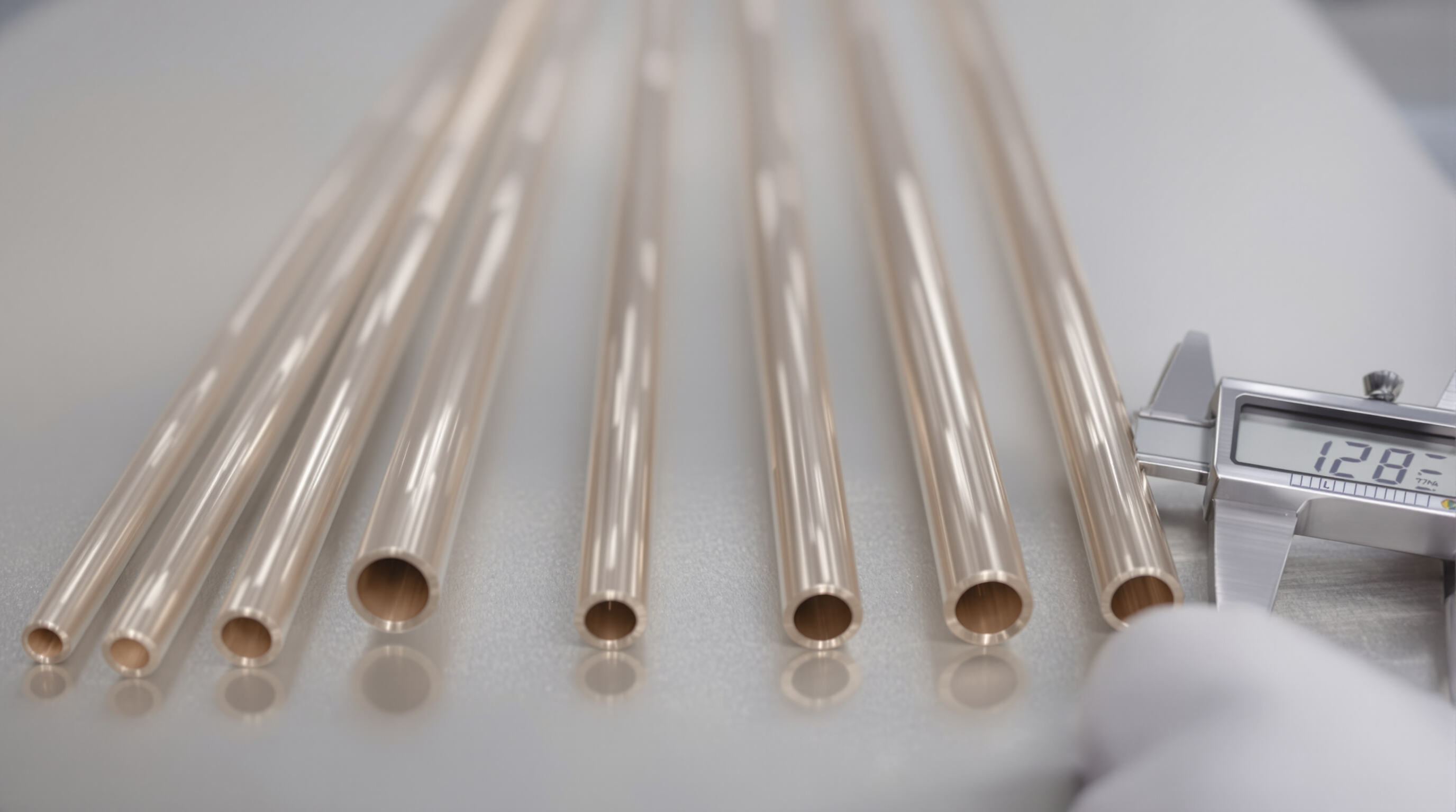 Technician measuring various capillary tubes of different lengths and diameters on a workbench