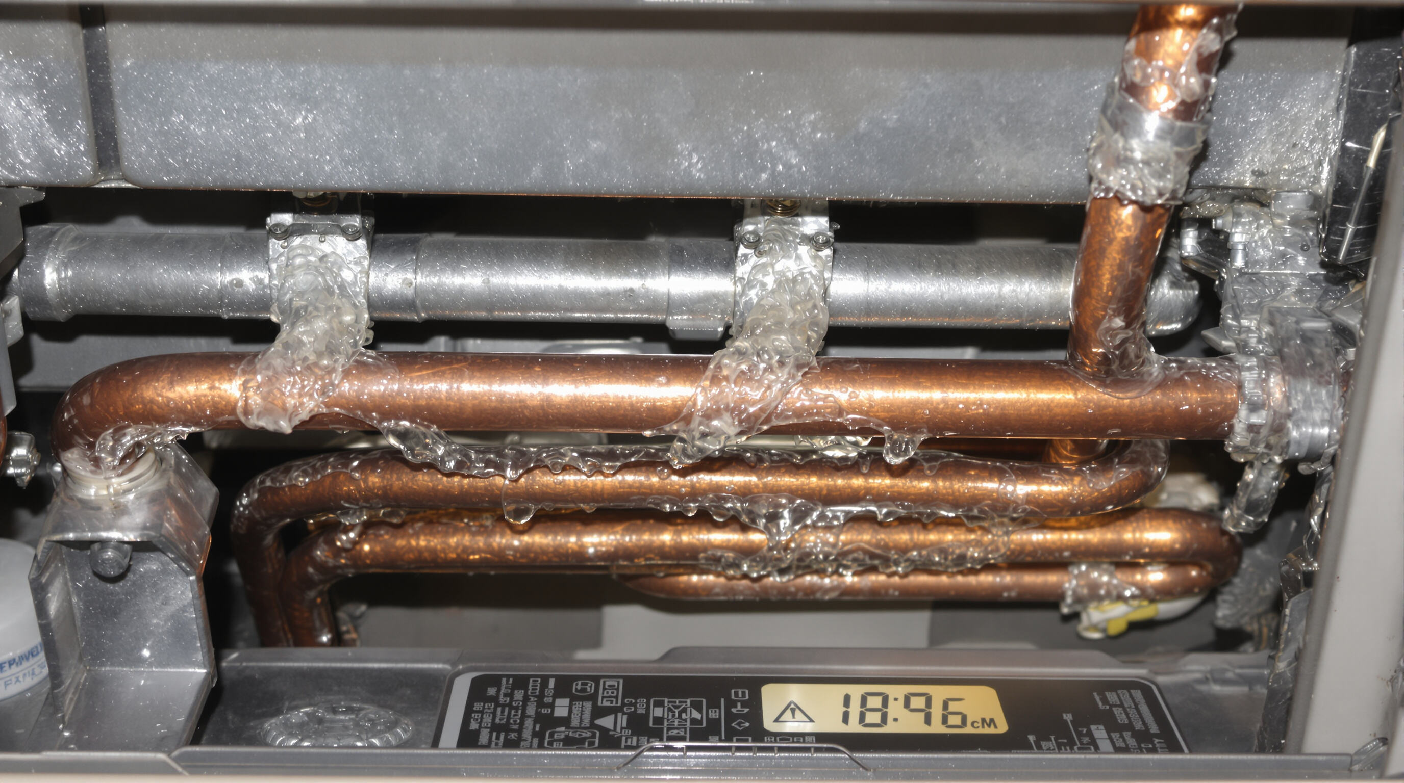 Detailed close-up of a copper capillary tube inside a home air conditioner showing refrigerant flow and condensation
