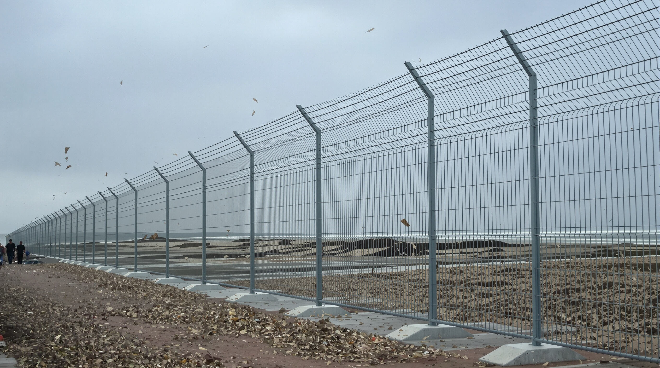 Temporary fencing with reinforced bases standing firm in windy coastal conditions
