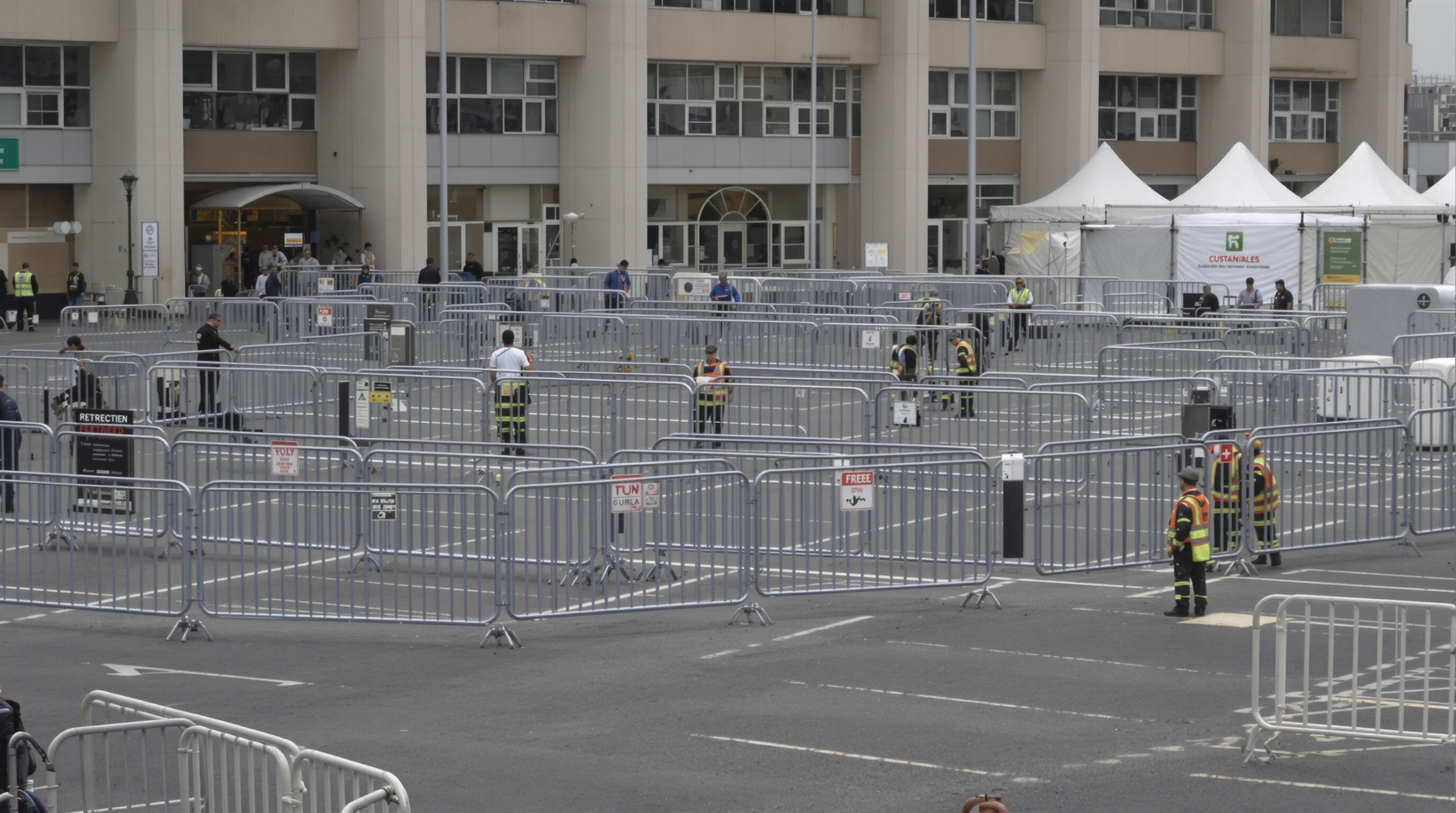 Steel barriers protecting restricted event zones, monitored by security staff